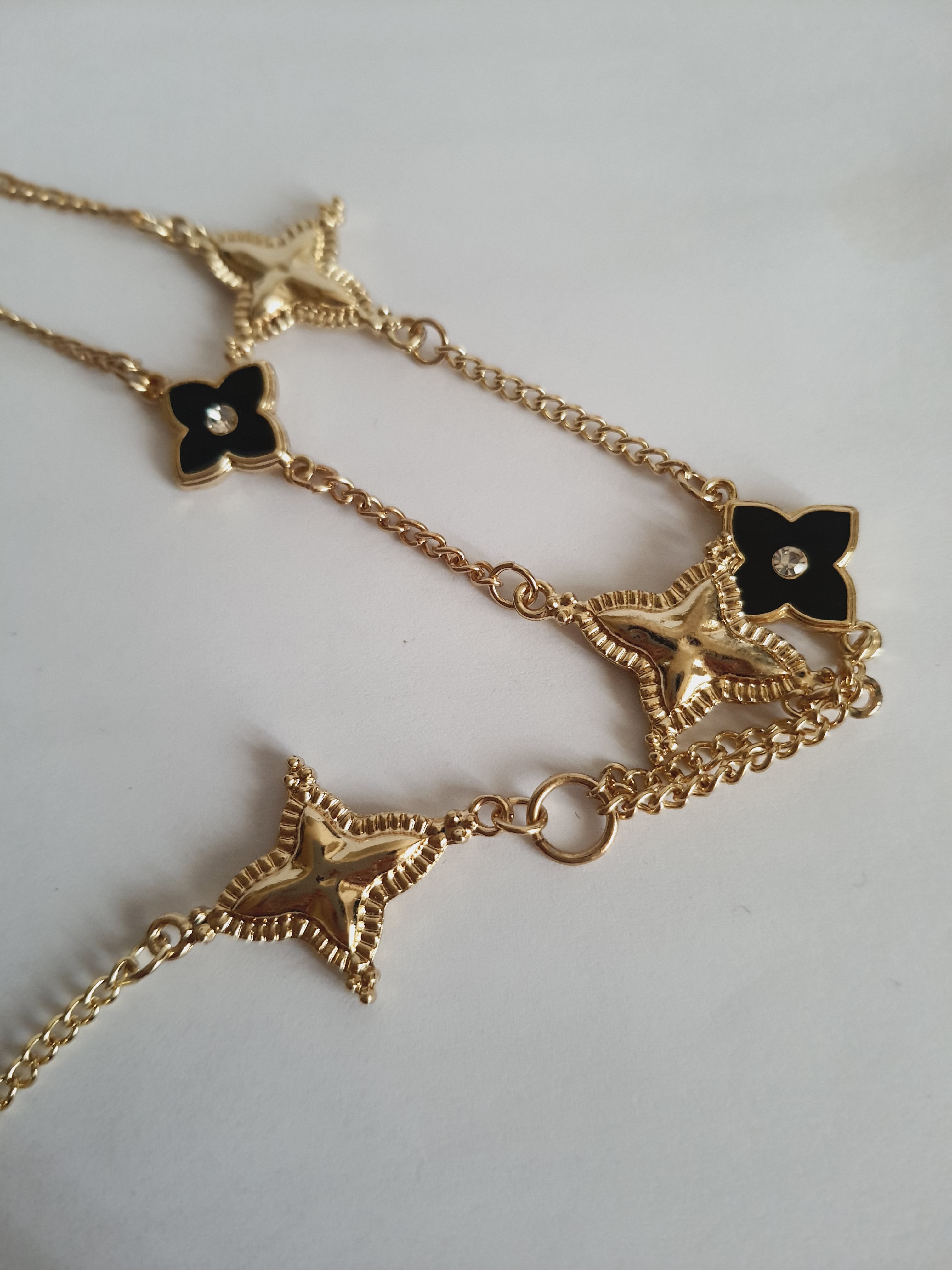 Naszyjnik złoty 58–65 cm ze stali nierdzewnej, zdobiony naprzemiennymi złotymi i czarnymi kwiatami z kryształkami, elegancki glamour, Rouge Bizu.