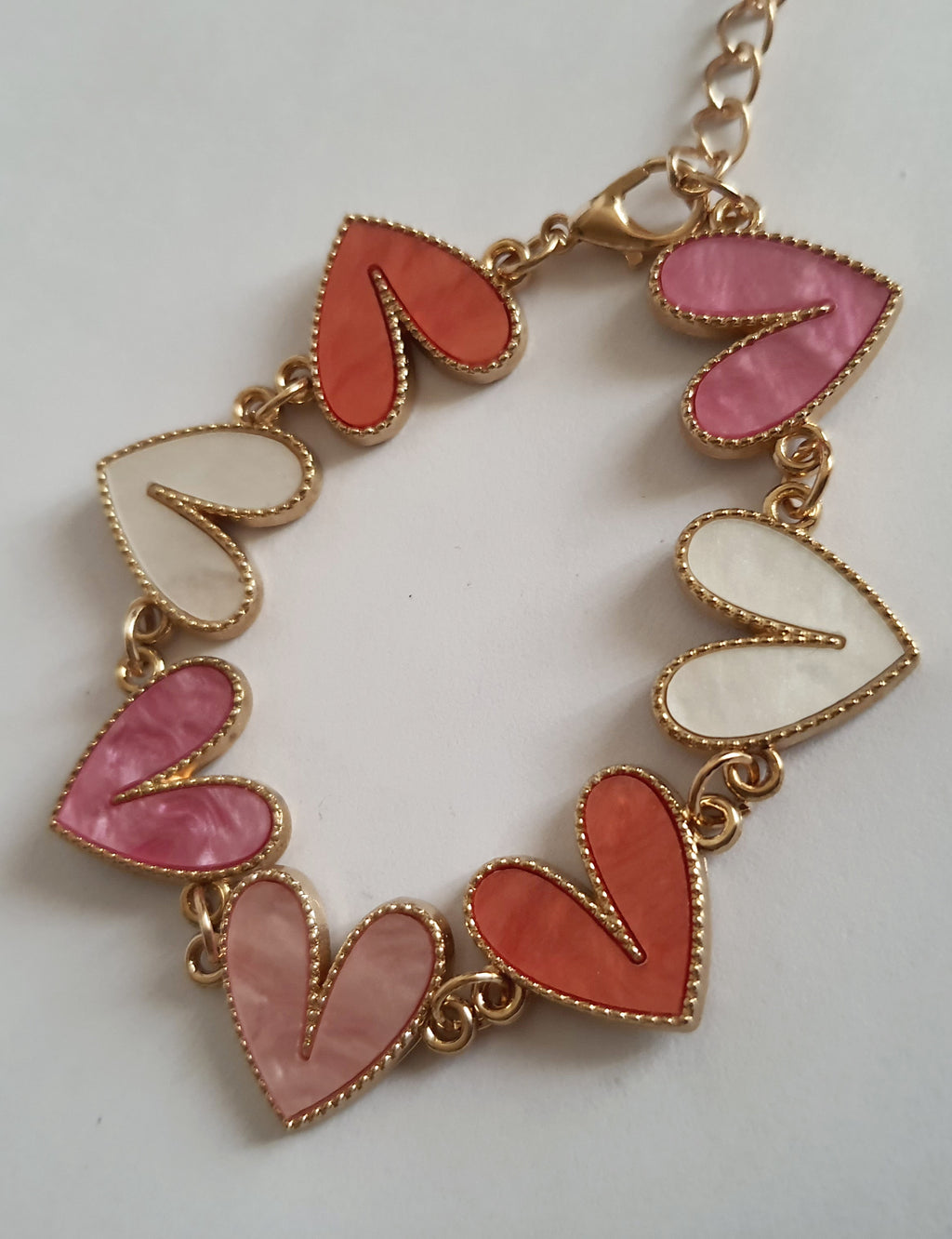 Bransoletka złota 17–22 cm ze stali nierdzewnej, zdobiona kolorowymi sercami w odcieniach różu, bieli i koralu, romantyczna i kobieca, Rouge Bizu.