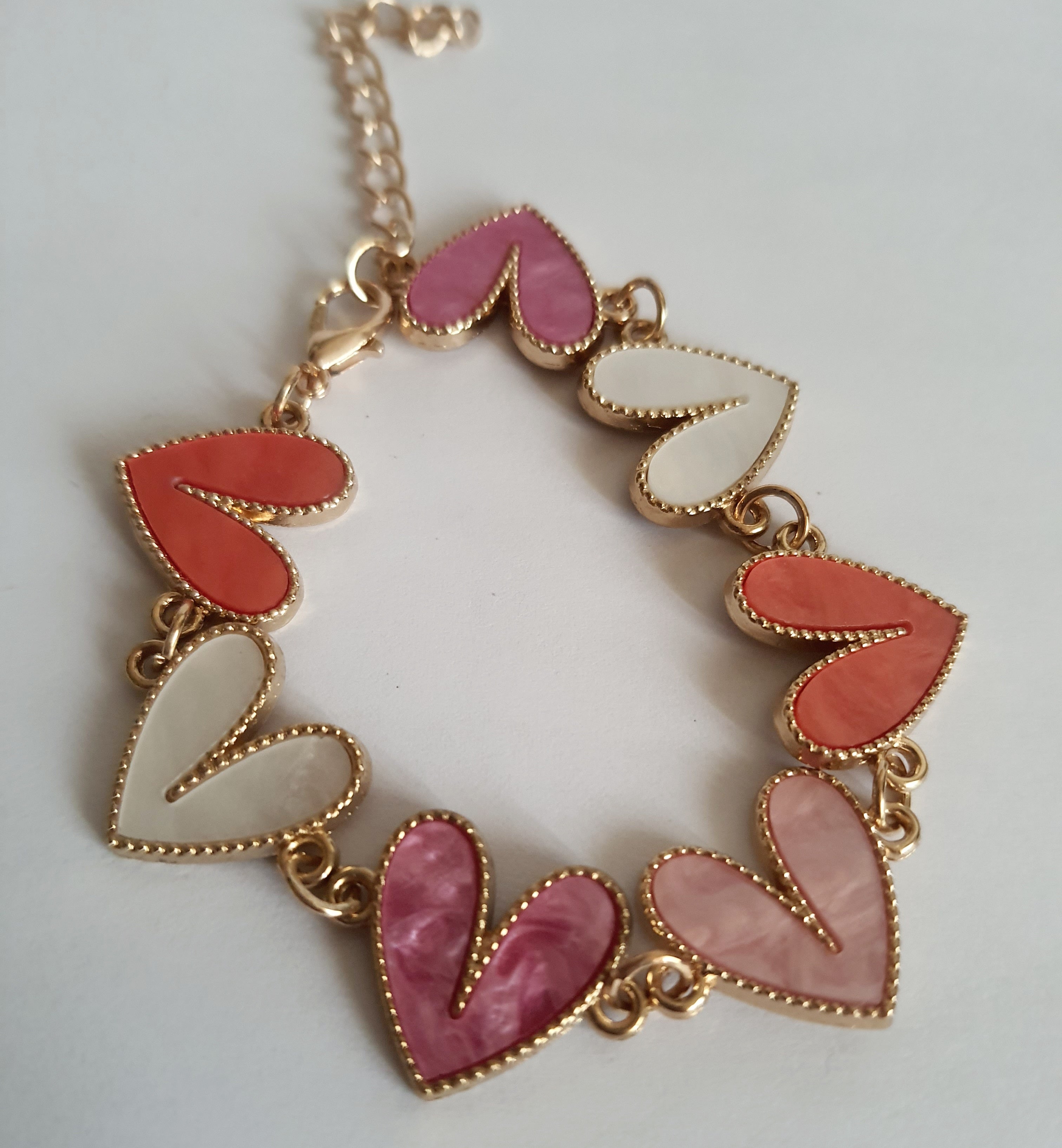 Bransoletka złota 17–22 cm ze stali nierdzewnej, zdobiona kolorowymi sercami w odcieniach różu, bieli i koralu, romantyczna i kobieca, Rouge Bizu. Stal nierdzewna, stal chirurgiczna, hipoalergiczna, nierdzewna, wodoodporna, jakość premium