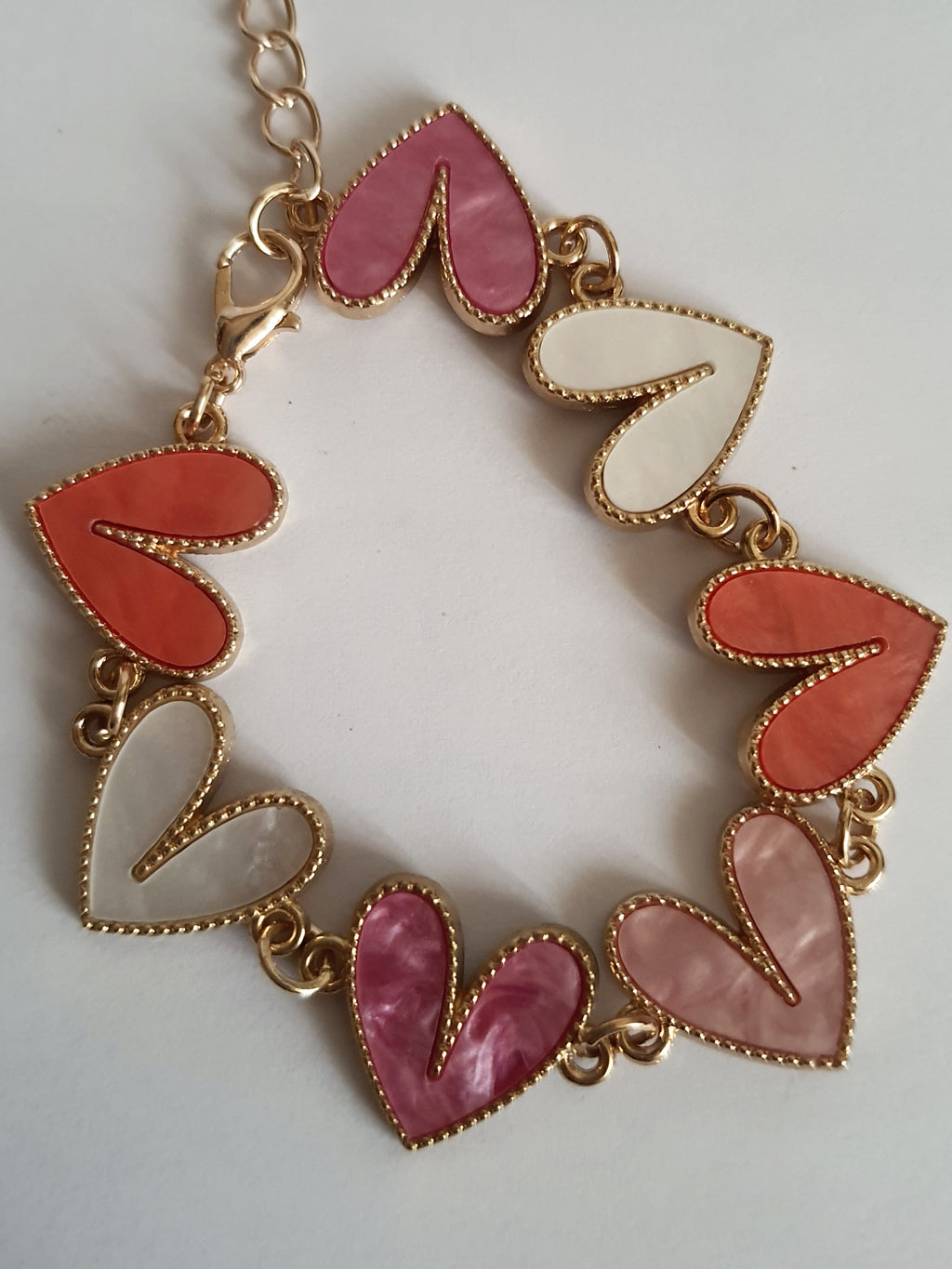 Bransoletka złota 17–22 cm ze stali nierdzewnej, zdobiona kolorowymi sercami w odcieniach różu, bieli i koralu, romantyczna i kobieca, Rouge Bizu. Stal nierdzewna, stal chirurgiczna, hipoalergiczna, nierdzewna, wodoodporna, jakość premium