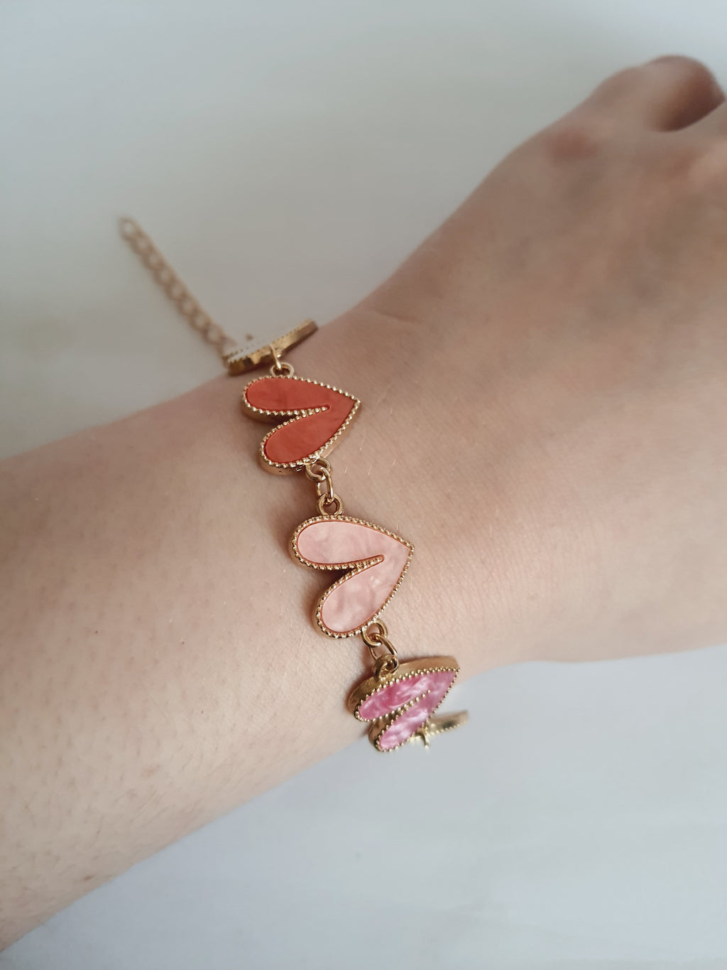 Bransoletka złota 17–22 cm ze stali nierdzewnej, zdobiona kolorowymi sercami w odcieniach różu, bieli i koralu, romantyczna i kobieca, Rouge Bizu. Stal nierdzewna, stal chirurgiczna, hipoalergiczna, nierdzewna, wodoodporna, jakość premium