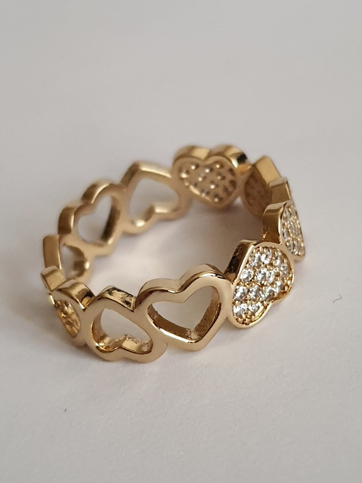 Pierścionek złoty 19 mm ze stali nierdzewnej, z motywem serc, część wysadzana białymi cyrkoniami, romantyczna i elegancka biżuteria, Rouge Bizu.#bizuteria #biżuteriapozłacana #stalnierdzewna #stalchirurgiczna #platerowane18k #wodoodporne #hipoalergiczne #retro #vintage #złotynaszyjnik #rougebizu