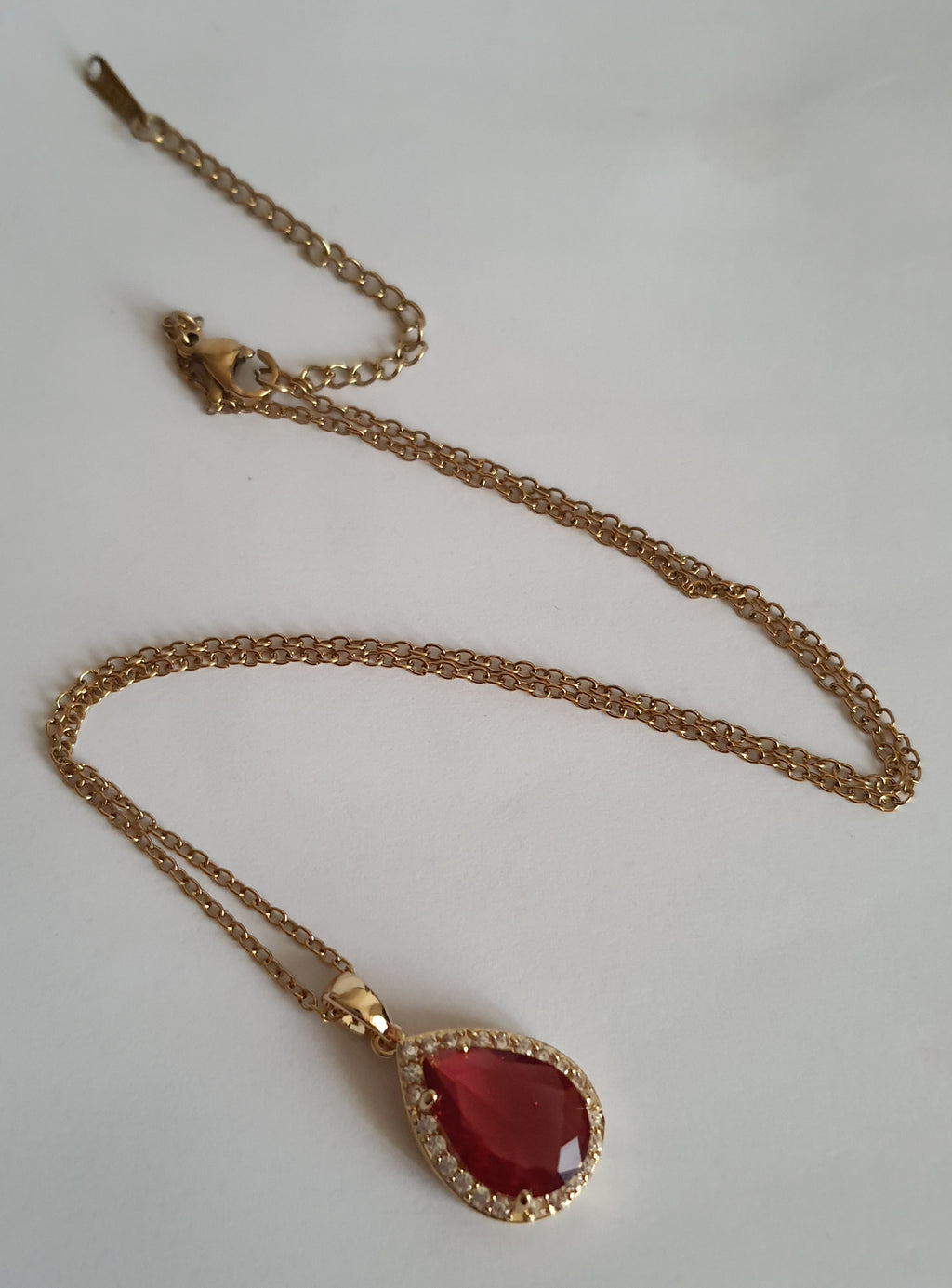 Naszyjnik złoty 41–47 cm ze stali nierdzewnej, zawieszka w kształcie łezki z rubinowym kryształem otoczonym cyrkoniami, Rouge Bizu.#bizuteria #biżuteriapozłacana #stalnierdzewna #stalchirurgiczna #platerowane18k #wodoodporne #hipoalergiczne #retro #vintage #złotynaszyjnik #rougebizu