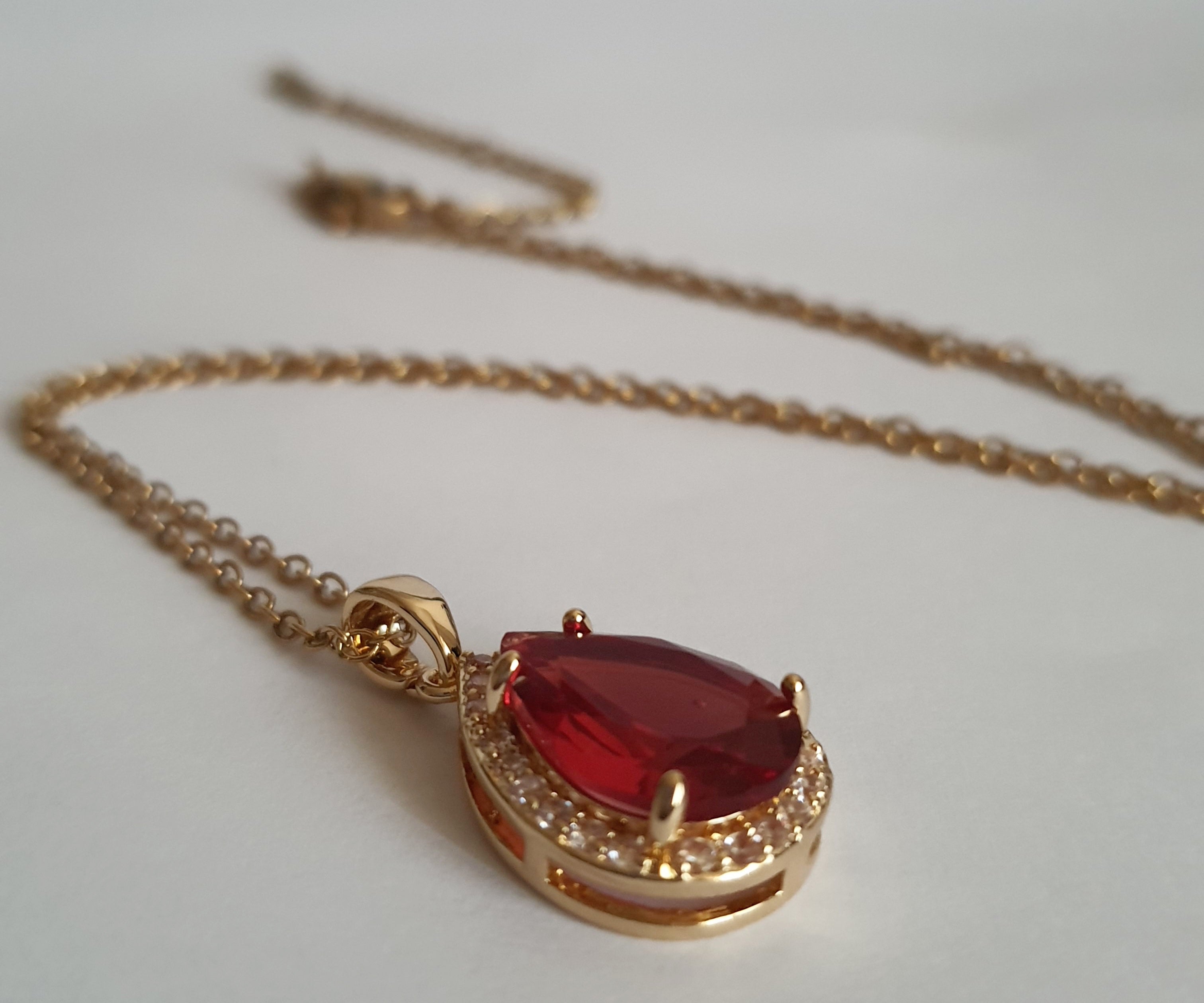 Naszyjnik złoty 41–47 cm ze stali nierdzewnej, zawieszka w kształcie łezki z rubinowym kryształem otoczonym cyrkoniami, Rouge Bizu.#bizuteria #biżuteriapozłacana #stalnierdzewna #stalchirurgiczna #platerowane18k #wodoodporne #hipoalergiczne #retro #vintage #złotynaszyjnik #rougebizu