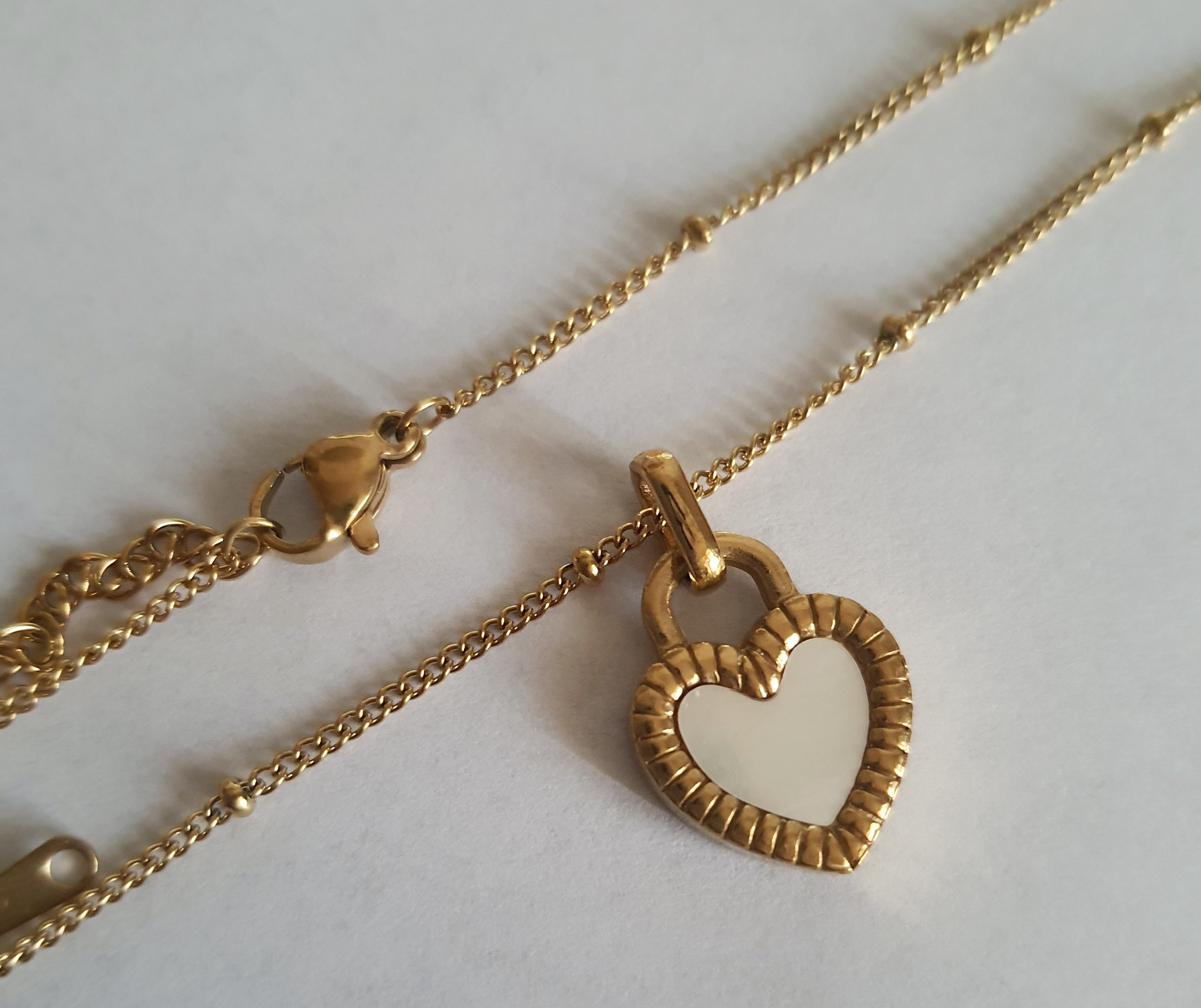 Złoty naszyjnik ze stali chirurgicznej z dwustronnym sercem – czarna i biała emalia. Regulowana długość 45–50 cm. Stal chirurgiczna, stal nierdzewna, wodoodporne, hipoalergiczne, jakość premium. RougeBizu.