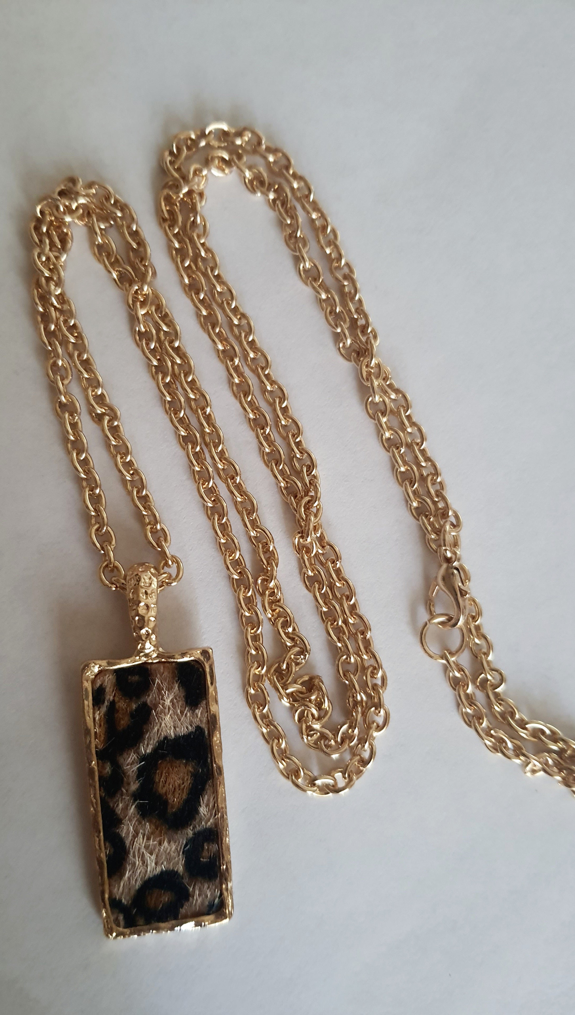 Złoty naszyjnik ze stali chirurgicznej z długim łańcuszkiem (81 cm) i prostokątną zawieszką w panterkowy wzór z imitacją futerka. Stal chirurgiczna, stal nierdzewna, wodoodporne, hipoalergiczne, jakość premium. RougeBizu.