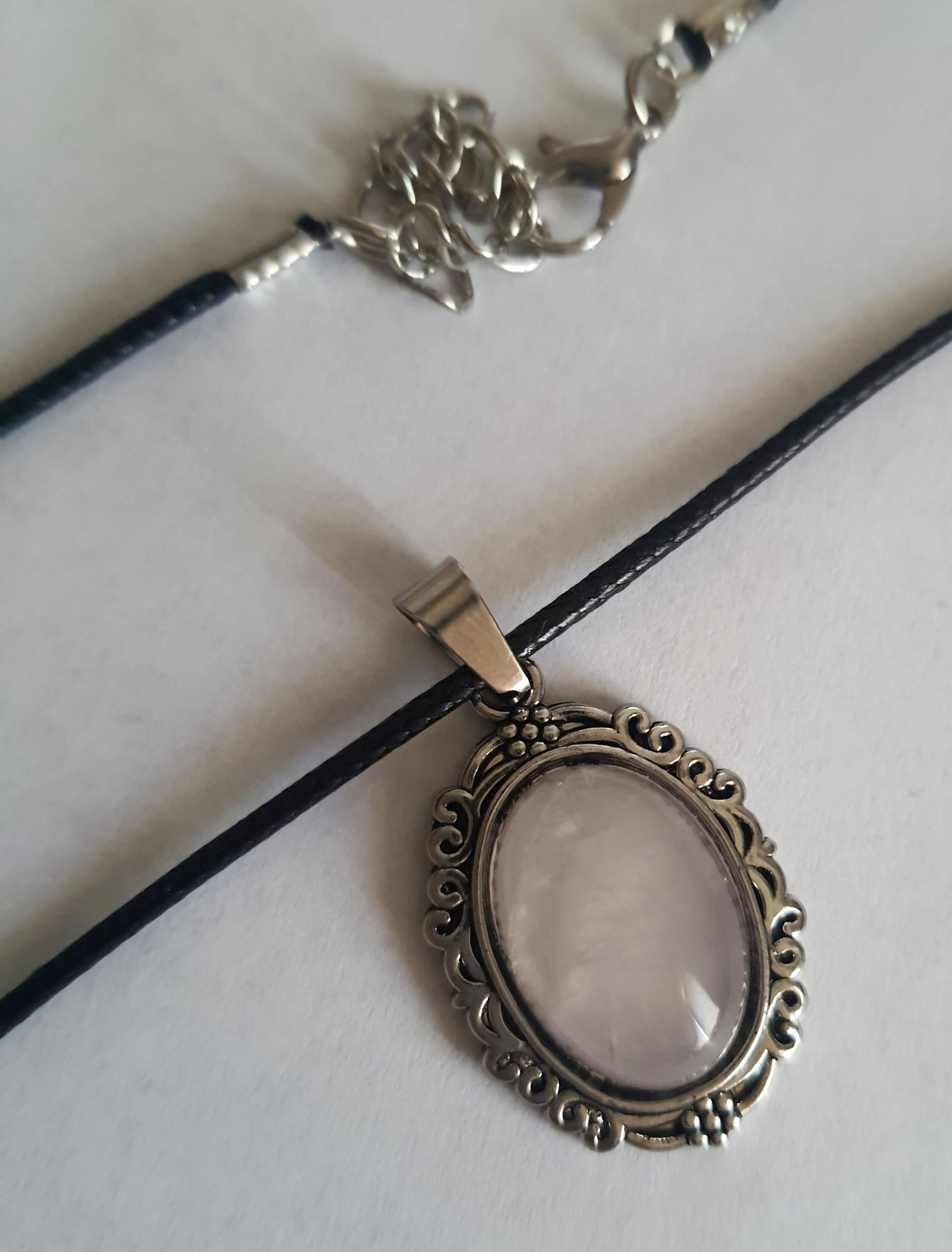 Naszyjnik vintage ze stali chirurgicznej z syntetycznym różowym kwarcem w ozdobnej srebrzystej ramce. Czarny rzemyk, długość regulowana 45–50 cm. Stal chirurgiczna, stal nierdzewna, wodoodporne, hipoalergiczne, jakość premium. RougeBizu.