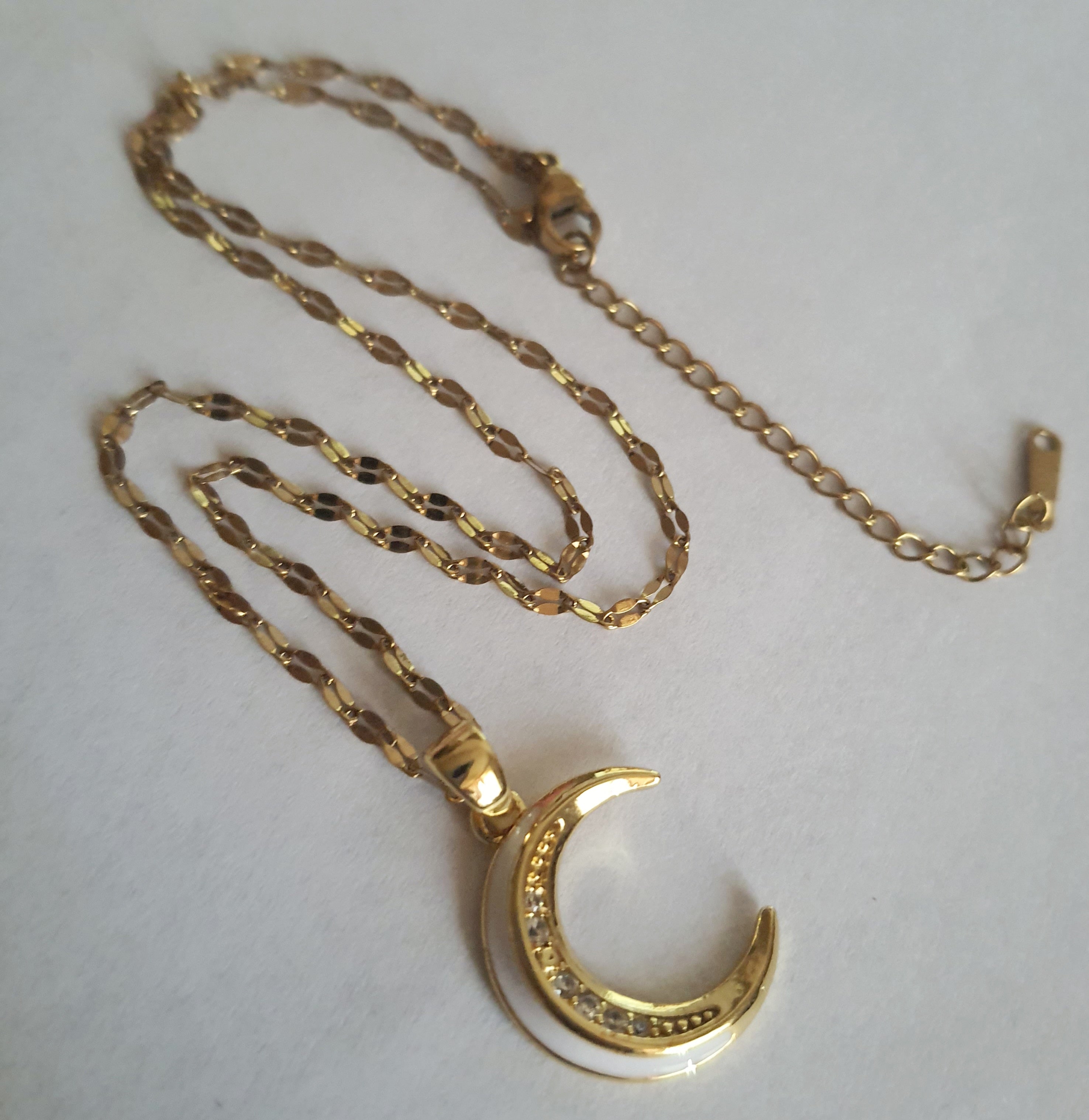 Złoty naszyjnik ze stali chirurgicznej z zawieszką w kształcie półksiężyca wysadzanego cyrkoniami. Regulowana długość 40–45 cm. Stal chirurgiczna, stal nierdzewna, wodoodporne, hipoalergiczne, jakość premium. RougeBizu.