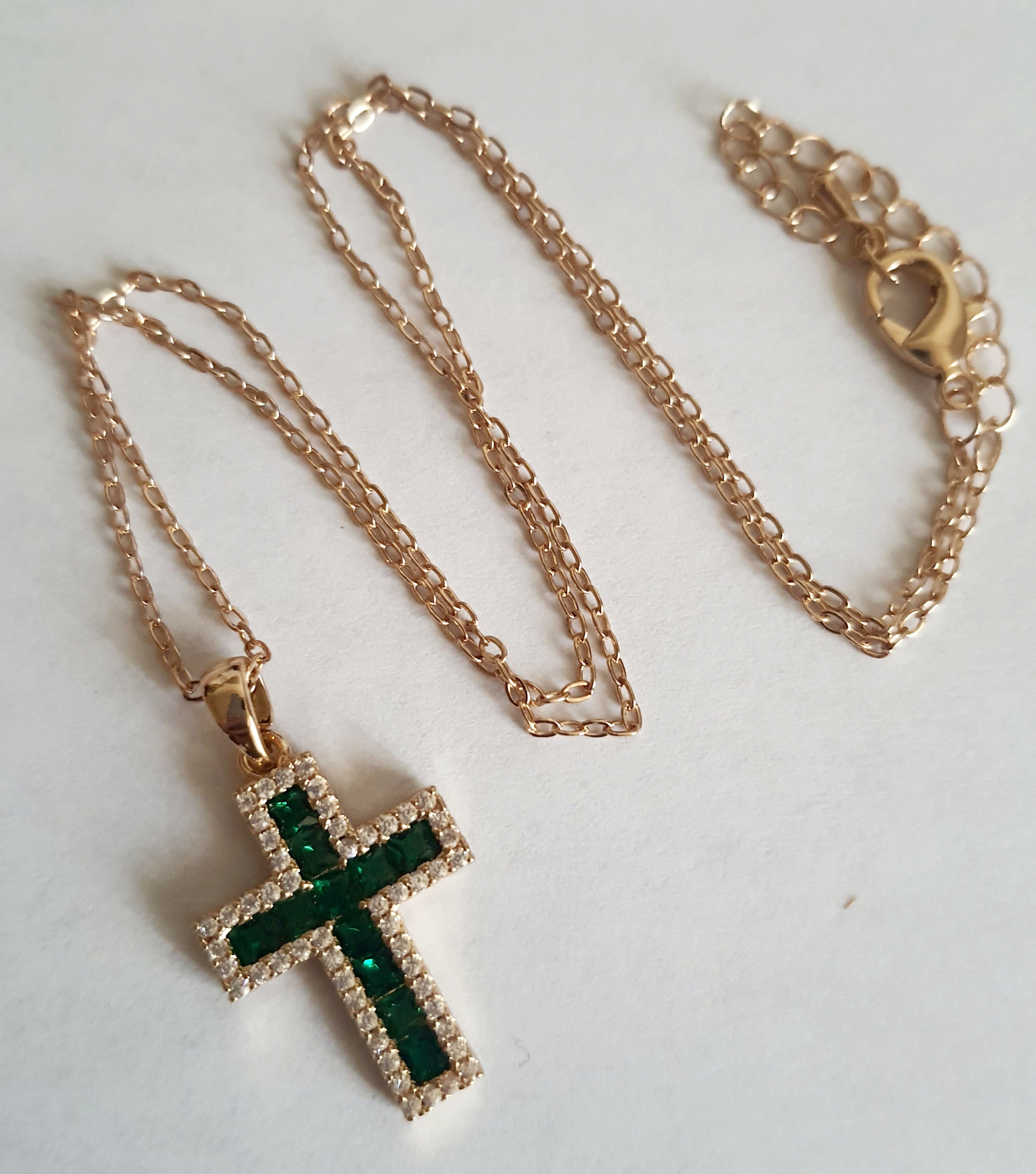 Złoty naszyjnik ze stali chirurgicznej z zawieszką w kształcie krzyża wysadzaną zielonymi kryształami i otoczoną cyrkoniami. Regulowana długość 40–45 cm. Stal chirurgiczna, stal nierdzewna, wodoodporne, hipoalergiczne, jakość premium. RougeBizu.