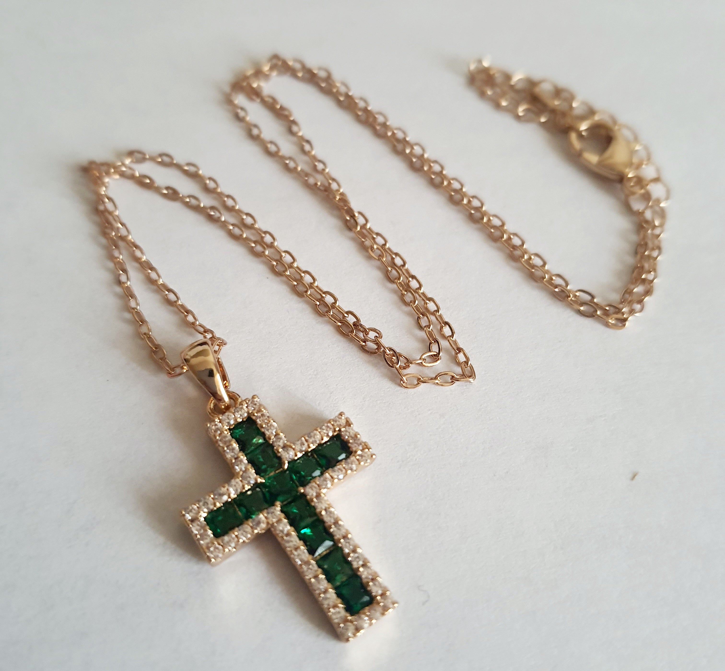 Złoty naszyjnik ze stali chirurgicznej z zawieszką w kształcie krzyża wysadzaną zielonymi kryształami i otoczoną cyrkoniami. Regulowana długość 40–45 cm. Stal chirurgiczna, stal nierdzewna, wodoodporne, hipoalergiczne, jakość premium. RougeBizu.