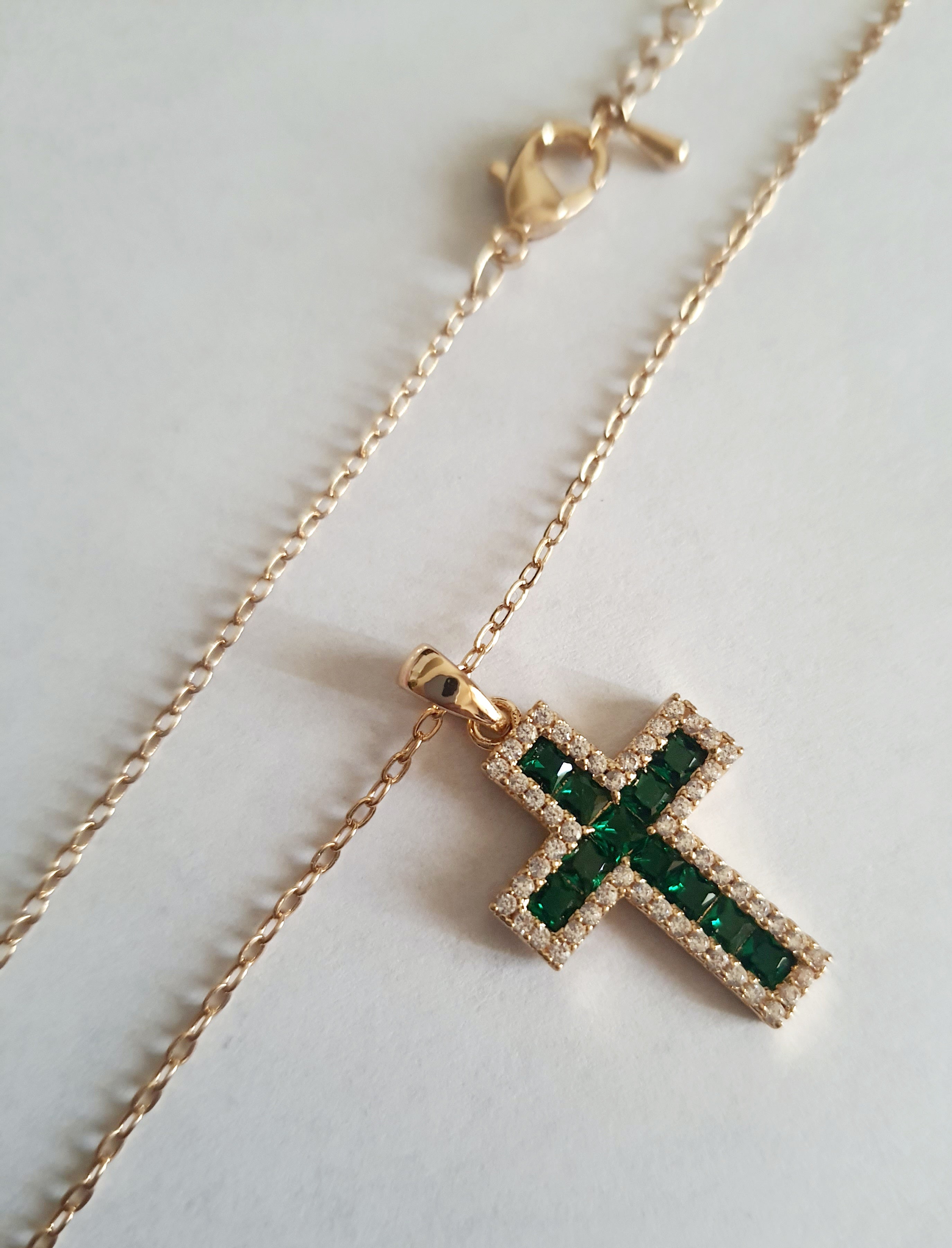 Złoty naszyjnik ze stali chirurgicznej z zawieszką w kształcie krzyża wysadzaną zielonymi kryształami i otoczoną cyrkoniami. Regulowana długość 40–45 cm. Stal chirurgiczna, stal nierdzewna, wodoodporne, hipoalergiczne, jakość premium. RougeBizu.