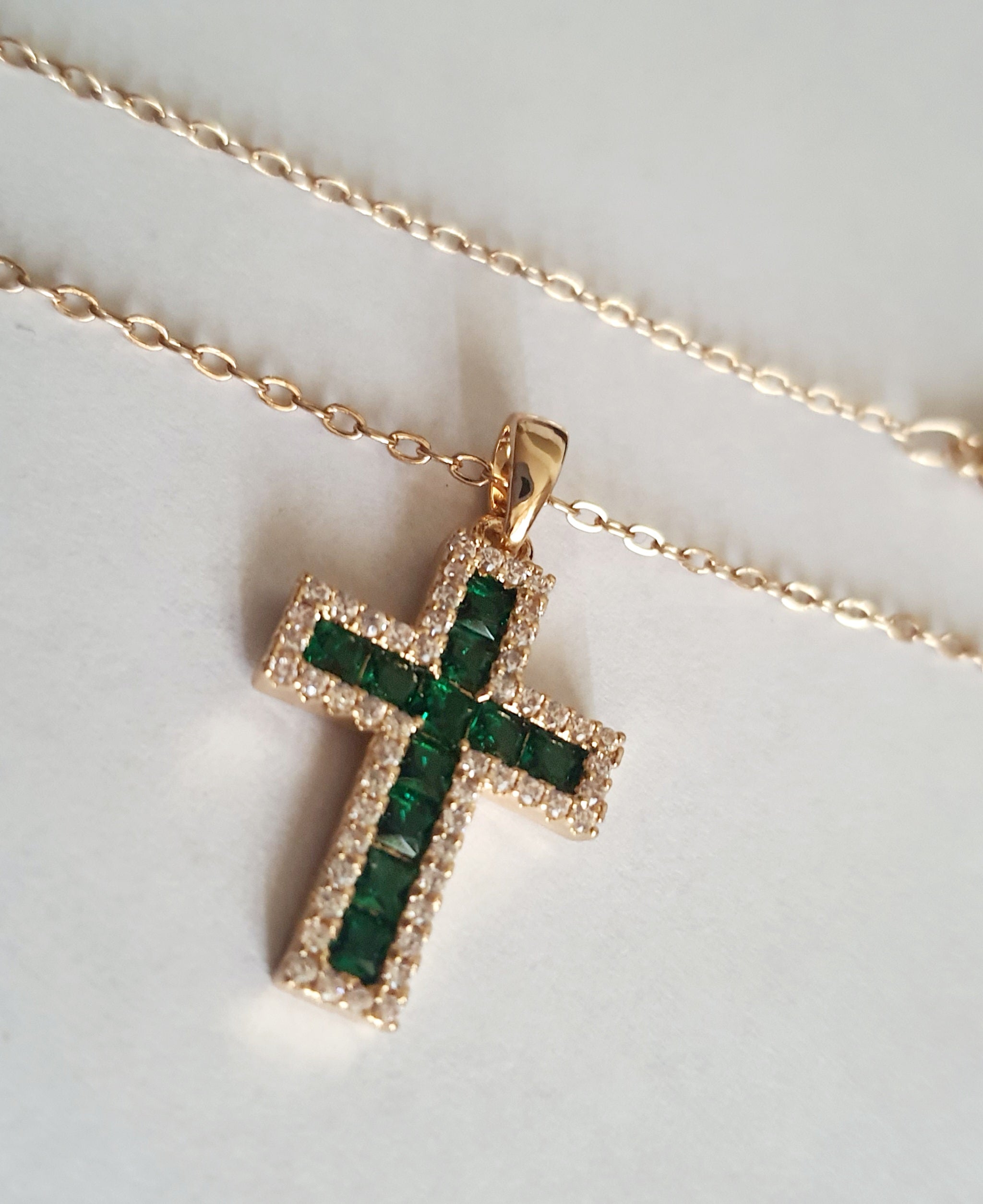 Złoty naszyjnik ze stali chirurgicznej z zawieszką w kształcie krzyża wysadzaną zielonymi kryształami i otoczoną cyrkoniami. Regulowana długość 40–45 cm. Stal chirurgiczna, stal nierdzewna, wodoodporne, hipoalergiczne, jakość premium. RougeBizu.