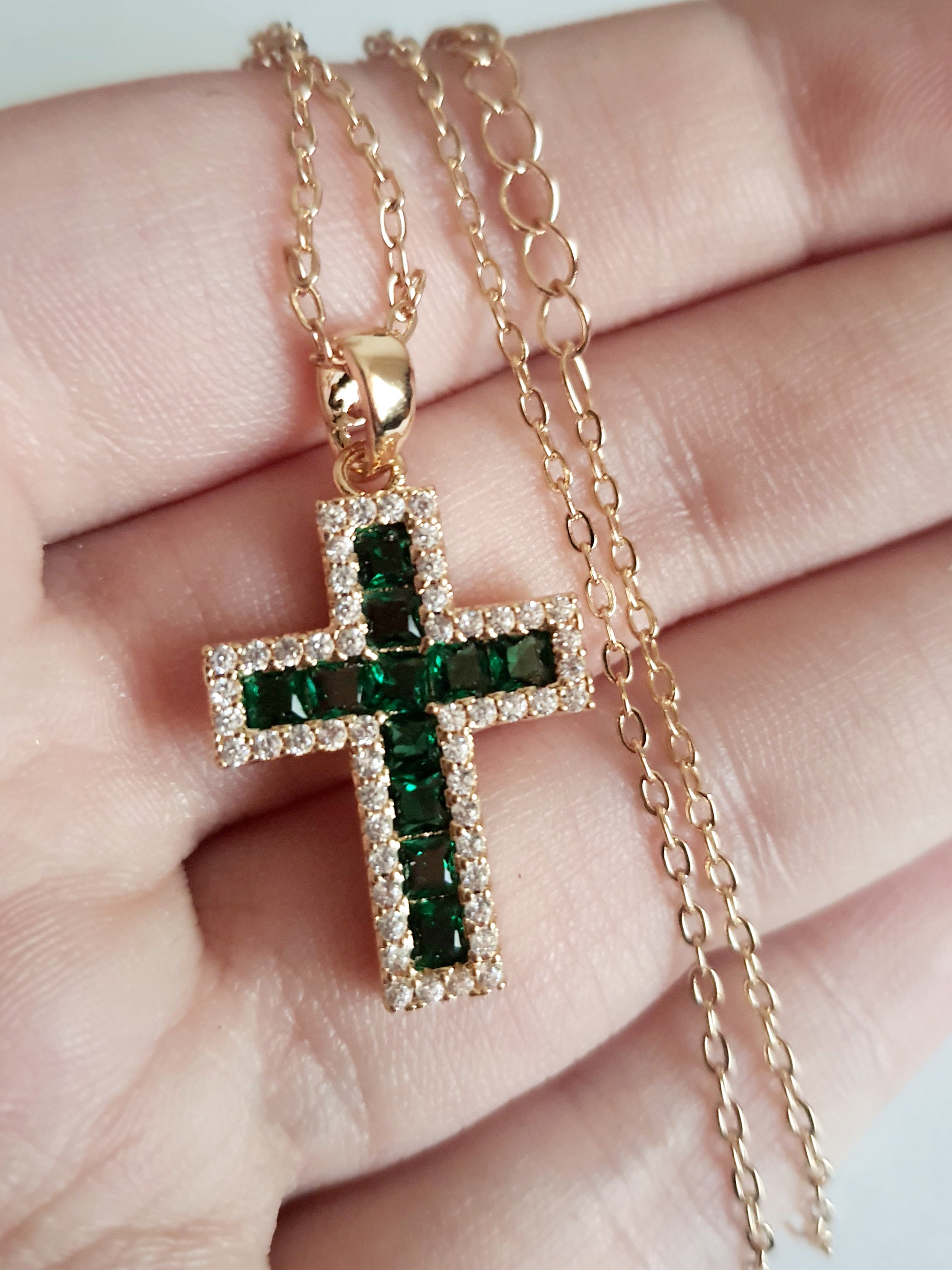 Złoty naszyjnik ze stali chirurgicznej z zawieszką w kształcie krzyża wysadzaną zielonymi kryształami i otoczoną cyrkoniami. Regulowana długość 40–45 cm. Stal chirurgiczna, stal nierdzewna, wodoodporne, hipoalergiczne, jakość premium. RougeBizu.