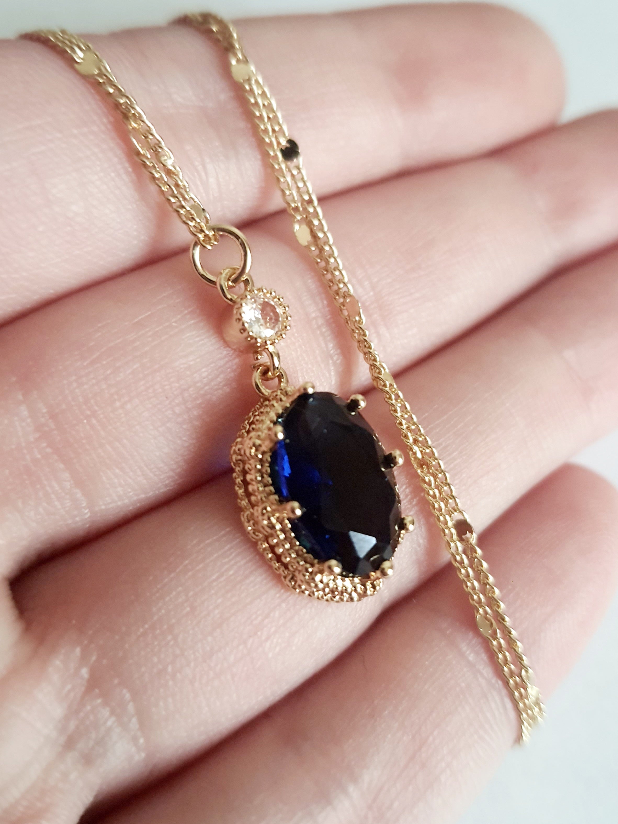 Złoty naszyjnik ze stali chirurgicznej z granatowym kamieniem w ozdobnej ramce i małą cyrkonią. Długość 47 cm. Stal chirurgiczna, stal nierdzewna, wodoodporne, hipoalergiczne, jakość premium. RougeBizu.