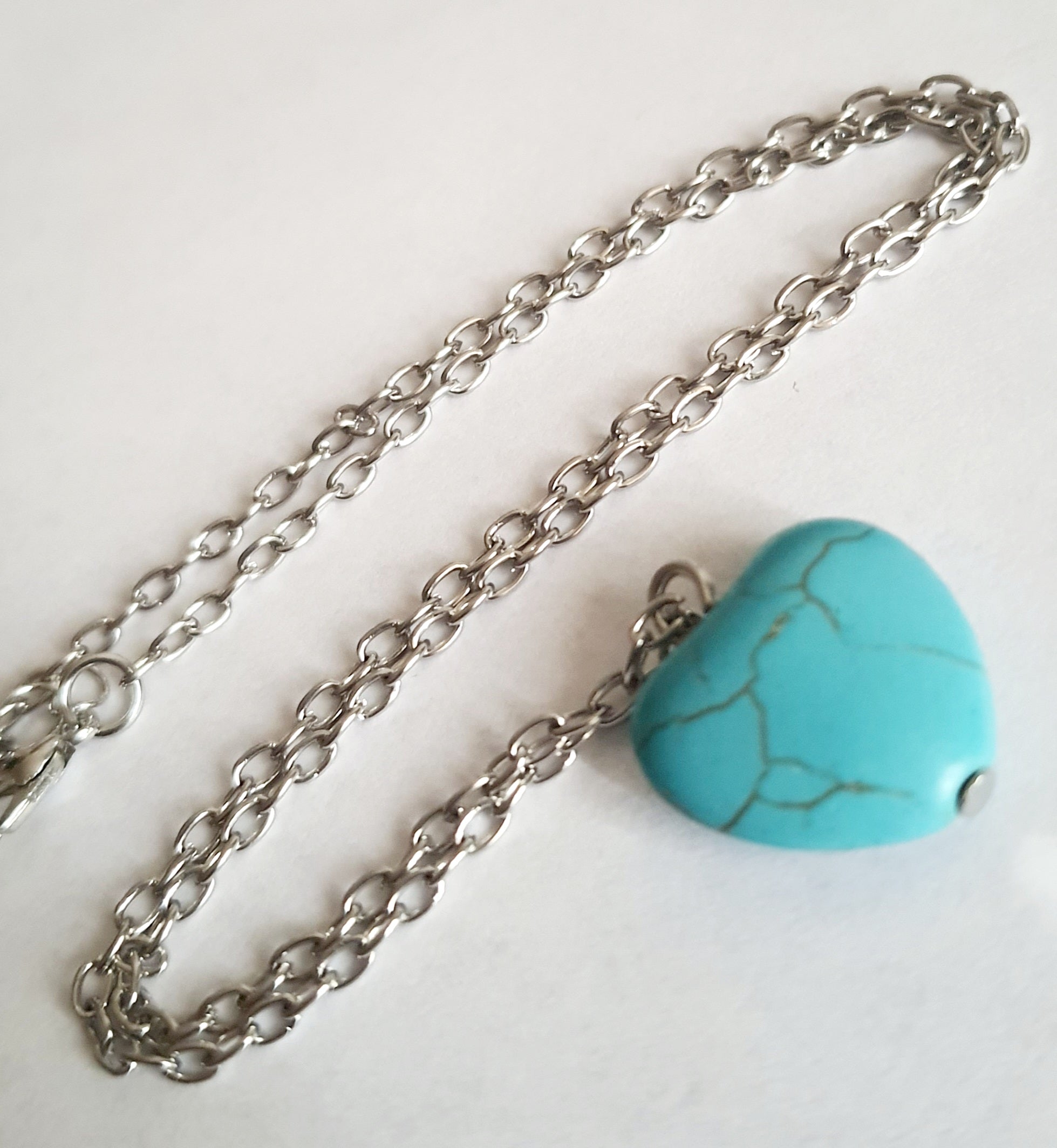 Srebrny naszyjnik ze stali chirurgicznej z zawieszką w kształcie turkusowego serduszka. Regulowana długość 41–48 cm. Stal chirurgiczna, stal nierdzewna, wodoodporne, hipoalergiczne, jakość premium. RougeBizu.