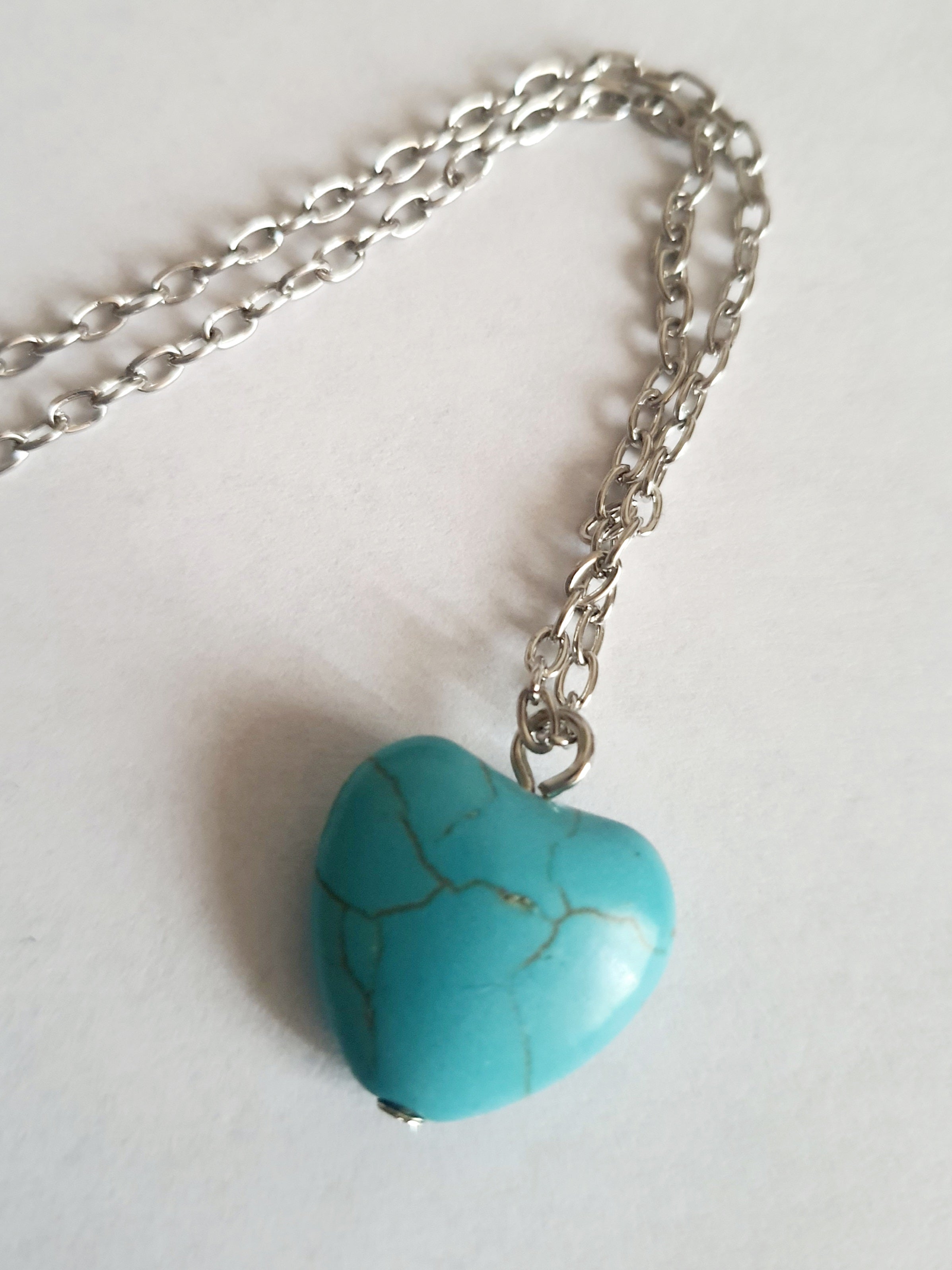 Srebrny naszyjnik ze stali chirurgicznej z zawieszką w kształcie turkusowego serduszka. Regulowana długość 41–48 cm. Stal chirurgiczna, stal nierdzewna, wodoodporne, hipoalergiczne, jakość premium. RougeBizu.