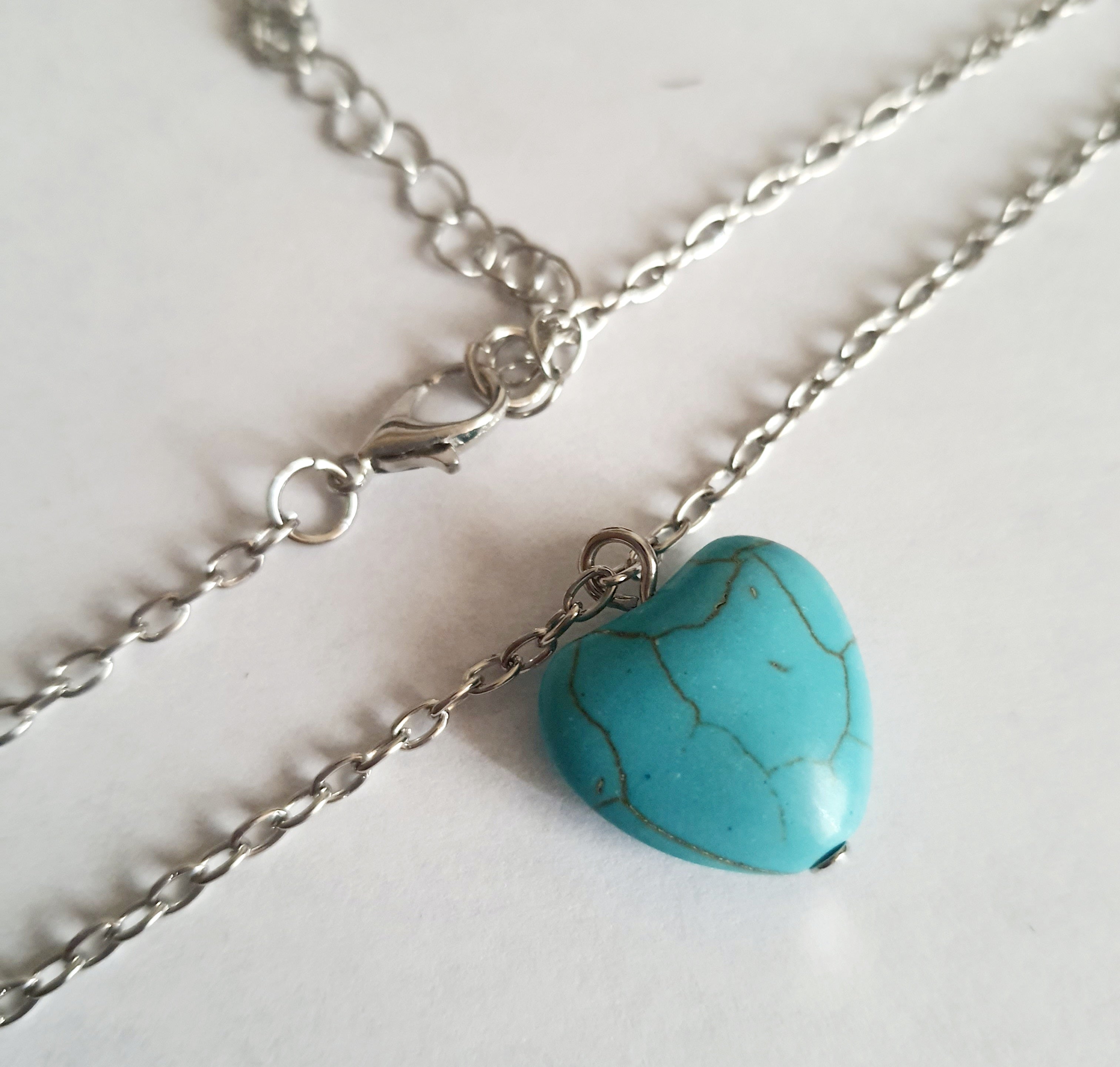 Srebrny naszyjnik ze stali chirurgicznej z zawieszką w kształcie turkusowego serduszka. Regulowana długość 41–48 cm. Stal chirurgiczna, stal nierdzewna, wodoodporne, hipoalergiczne, jakość premium. RougeBizu.