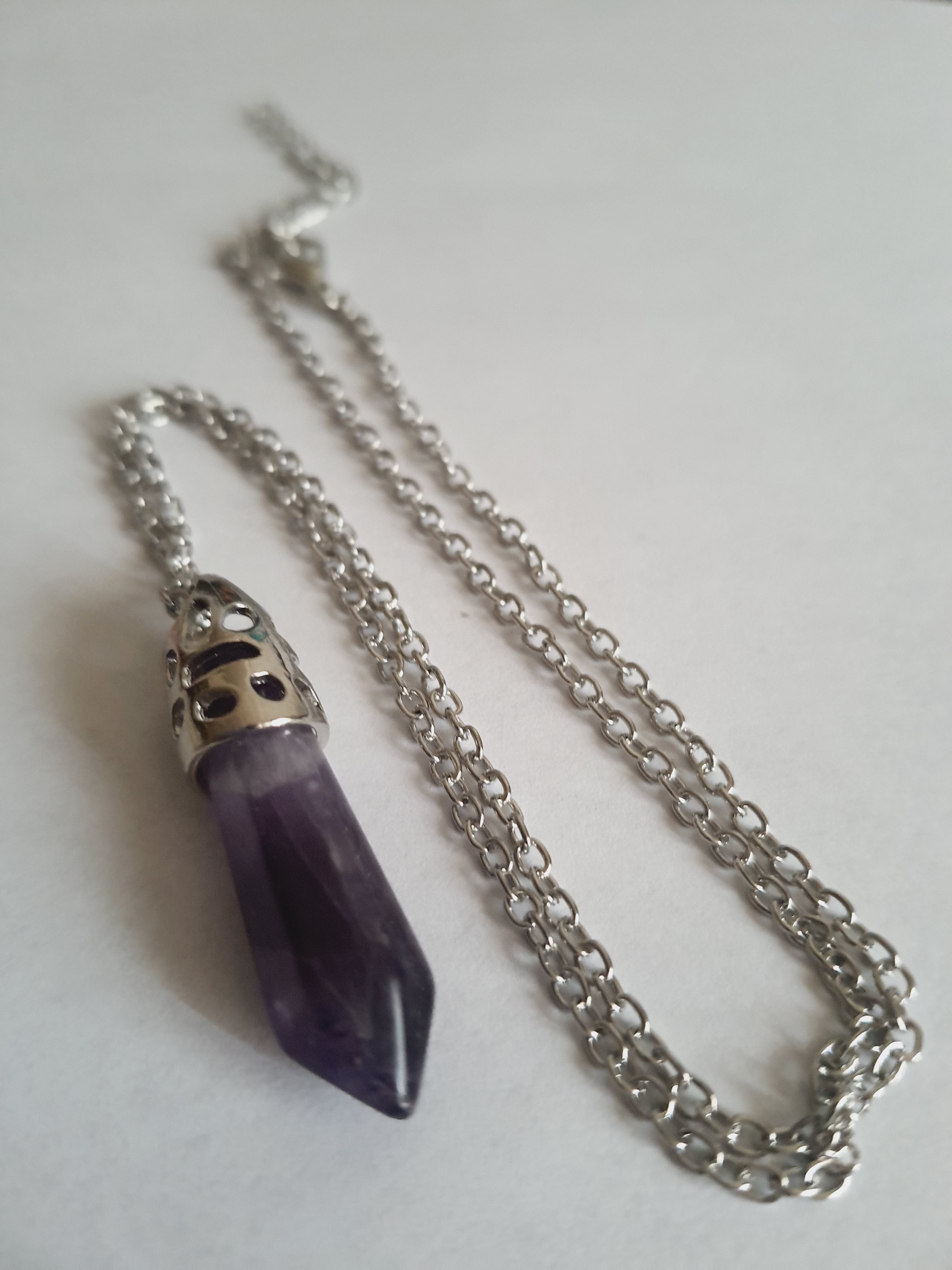 Srebrny naszyjnik ze stali chirurgicznej z zawieszką w postaci syntetycznego ametystu w kształcie szpica. Regulowana długość 48–52 cm. Stal chirurgiczna, stal nierdzewna, wodoodporne, hipoalergiczne, jakość premium. RougeBizu.