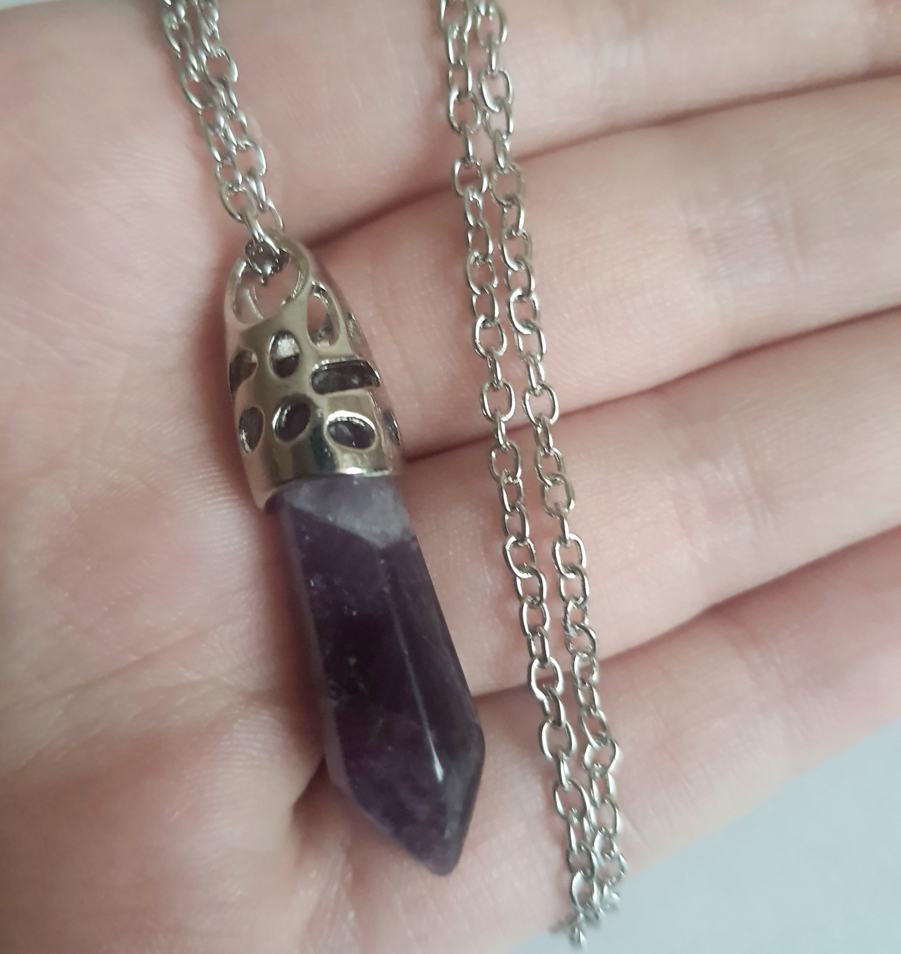 Srebrny naszyjnik ze stali chirurgicznej z zawieszką w postaci syntetycznego ametystu w kształcie szpica. Regulowana długość 48–52 cm. Stal chirurgiczna, stal nierdzewna, wodoodporne, hipoalergiczne, jakość premium. RougeBizu.