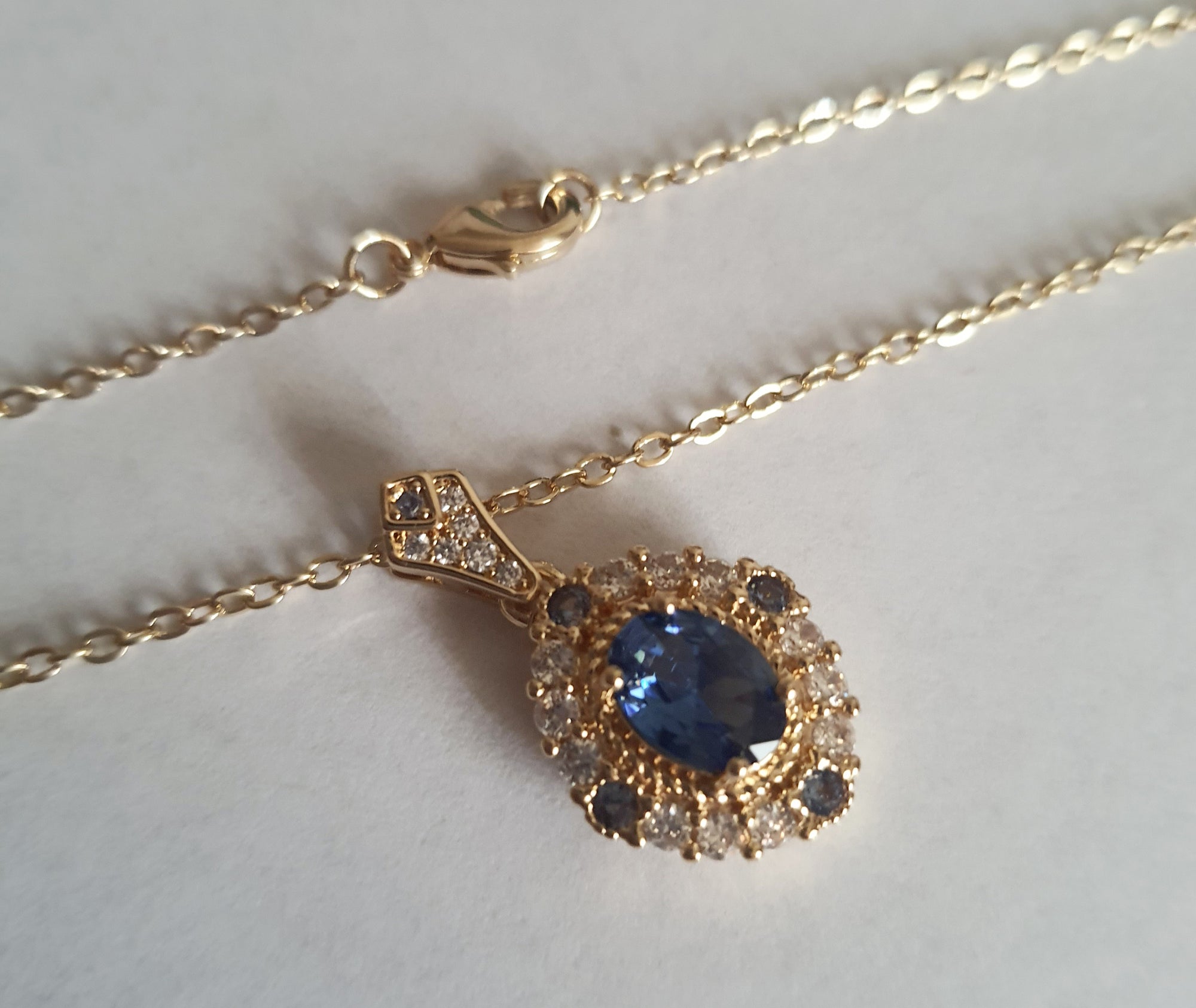 Złoty naszyjnik ze stali chirurgicznej z niebieskim kamieniem i cyrkoniami. Długość 47 cm. Biżuteria elegancka, klasyczna, wieczorowa, stal nierdzewna, hipoalergiczna. RougeBizu.