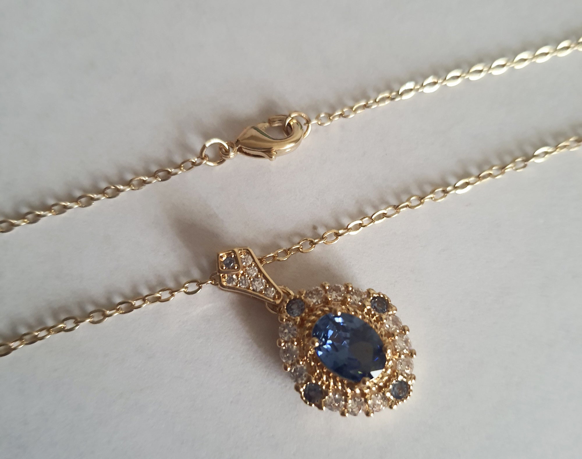 Złoty naszyjnik ze stali chirurgicznej z niebieskim kamieniem i cyrkoniami. Długość 47 cm. Biżuteria elegancka, klasyczna, wieczorowa, stal nierdzewna, hipoalergiczna. RougeBizu.