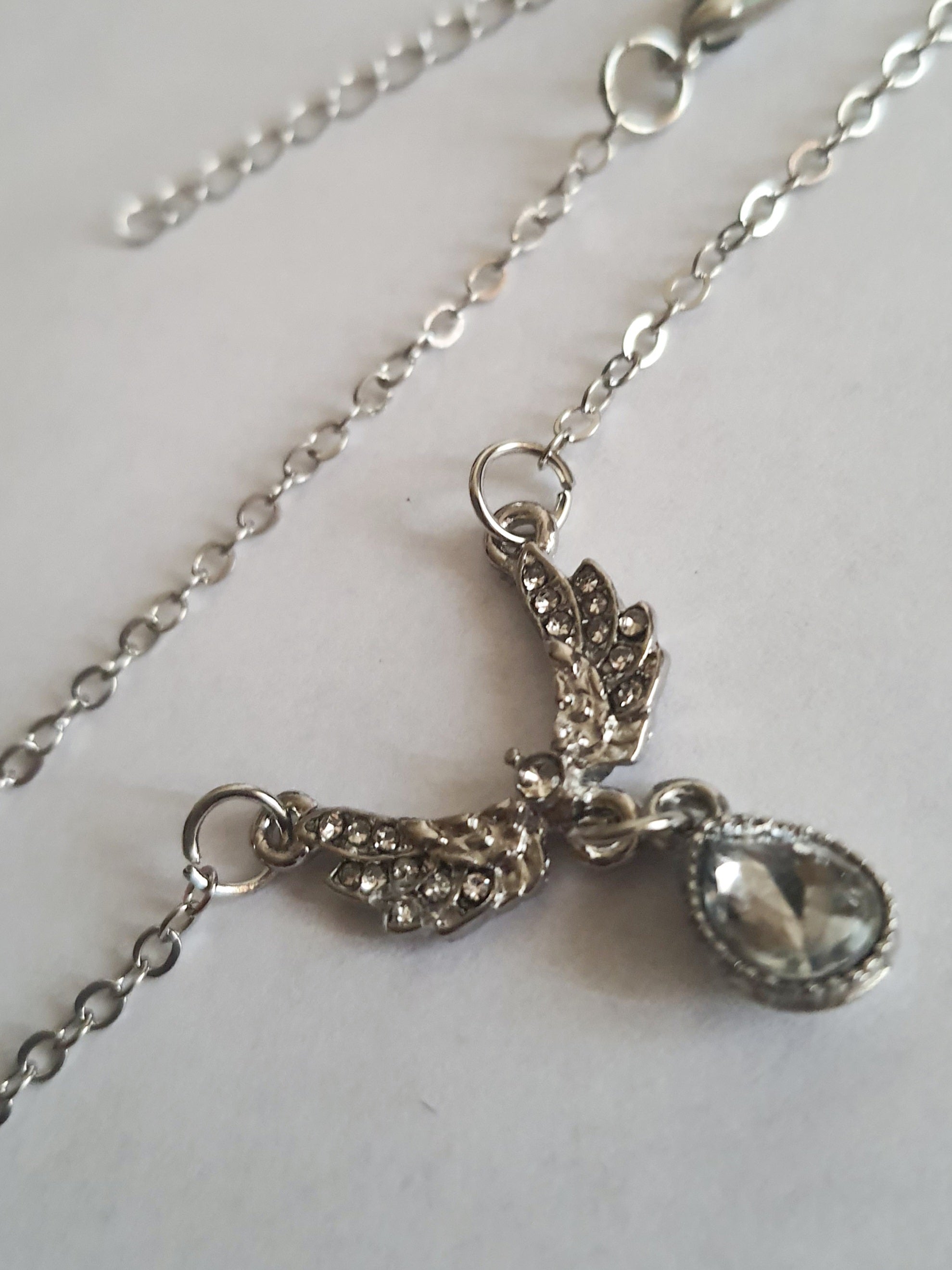 Srebrny naszyjnik ze stali nierdzewnej – stal chirurgiczna, wodoodporny, hipoalergiczny, jakość premium. Zawieszka w kształcie gołębia wysadzanego cyrkoniami z kryształową łzą. Długość łańcuszka 42–49 cm. RougeBizu.