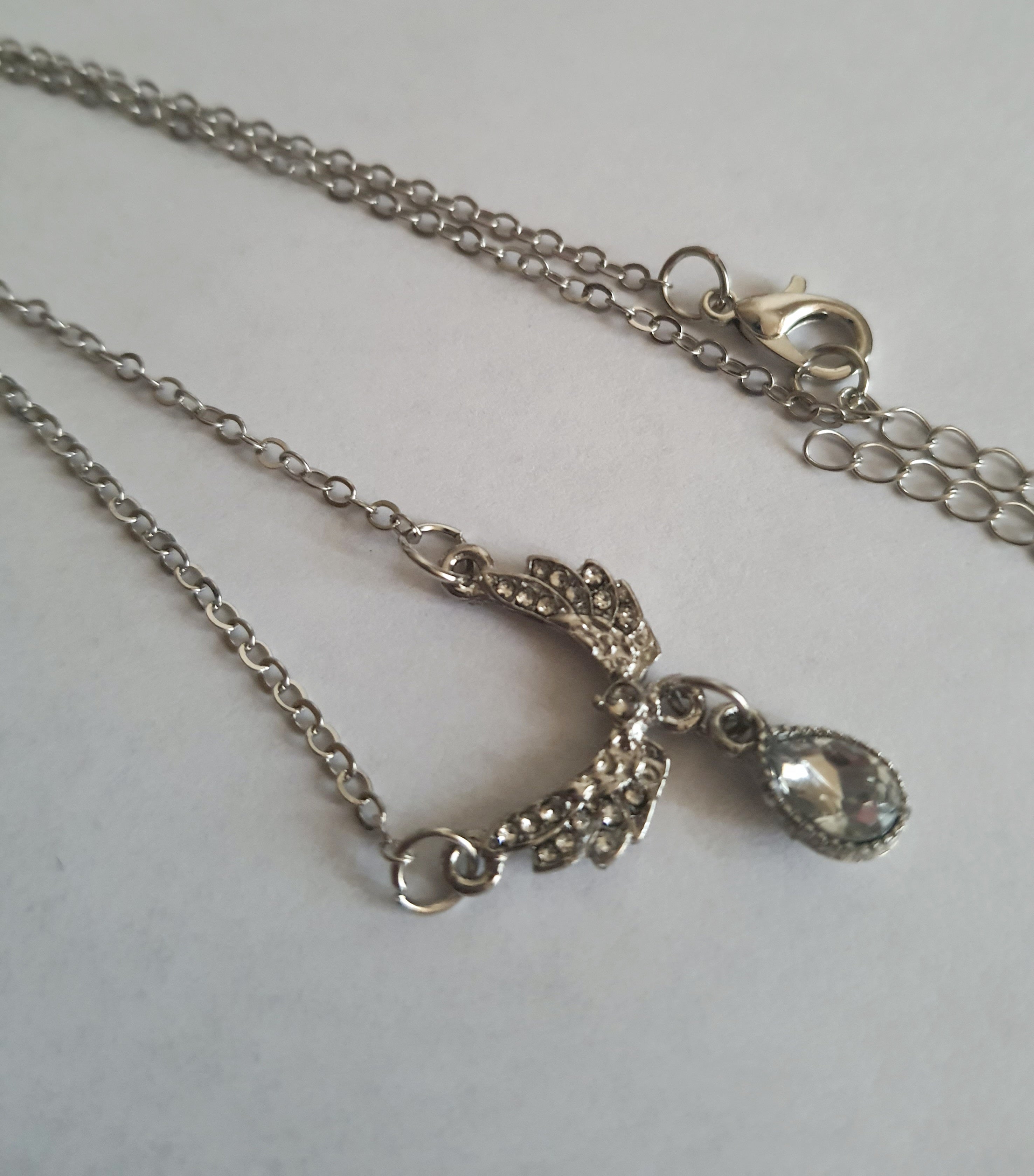 Srebrny naszyjnik ze stali nierdzewnej – stal chirurgiczna, wodoodporny, hipoalergiczny, jakość premium. Zawieszka w kształcie gołębia wysadzanego cyrkoniami z kryształową łzą. Długość łańcuszka 42–49 cm. RougeBizu.