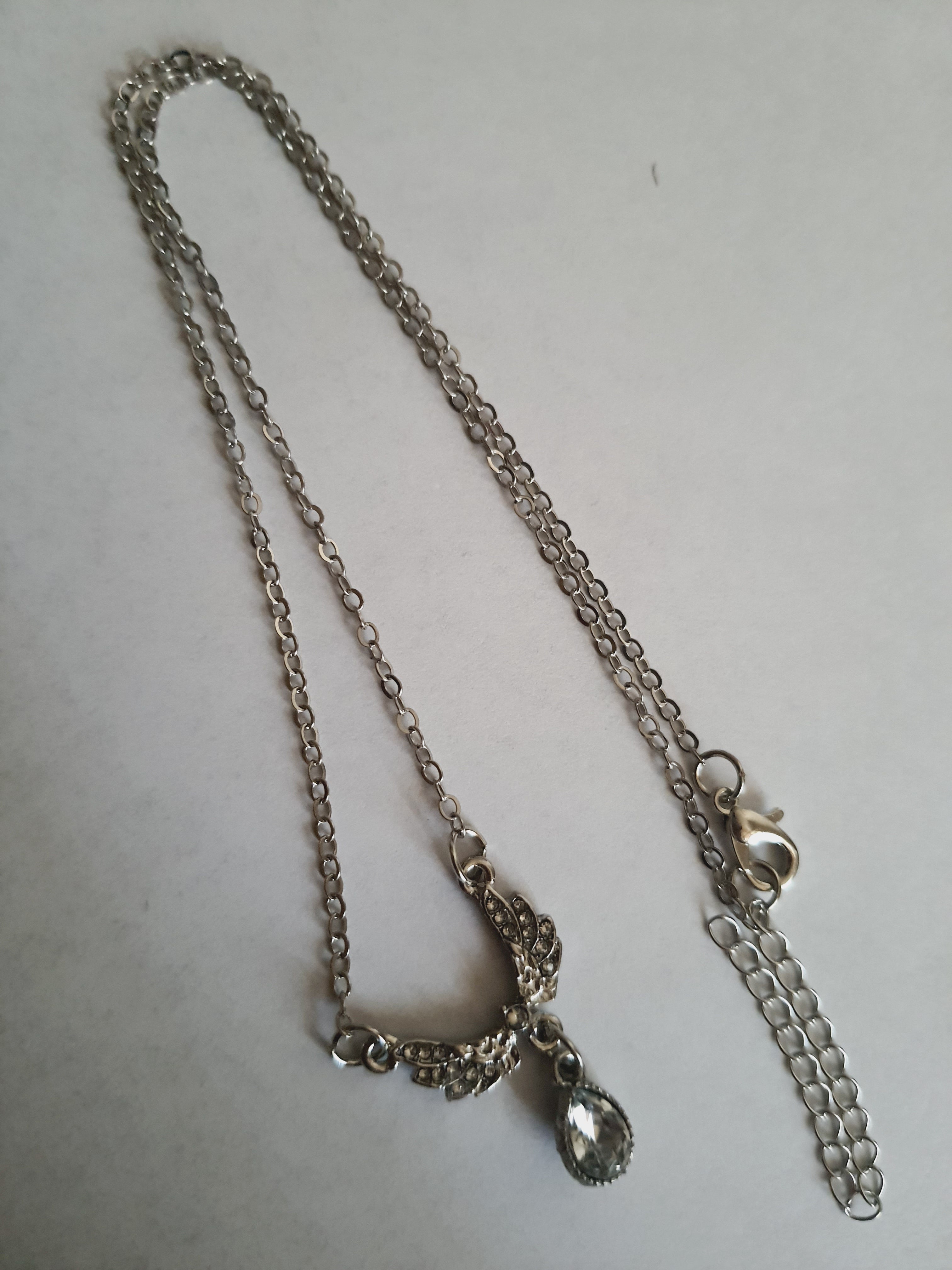 Srebrny naszyjnik ze stali nierdzewnej – stal chirurgiczna, wodoodporny, hipoalergiczny, jakość premium. Zawieszka w kształcie gołębia wysadzanego cyrkoniami z kryształową łzą. Długość łańcuszka 42–49 cm. RougeBizu.