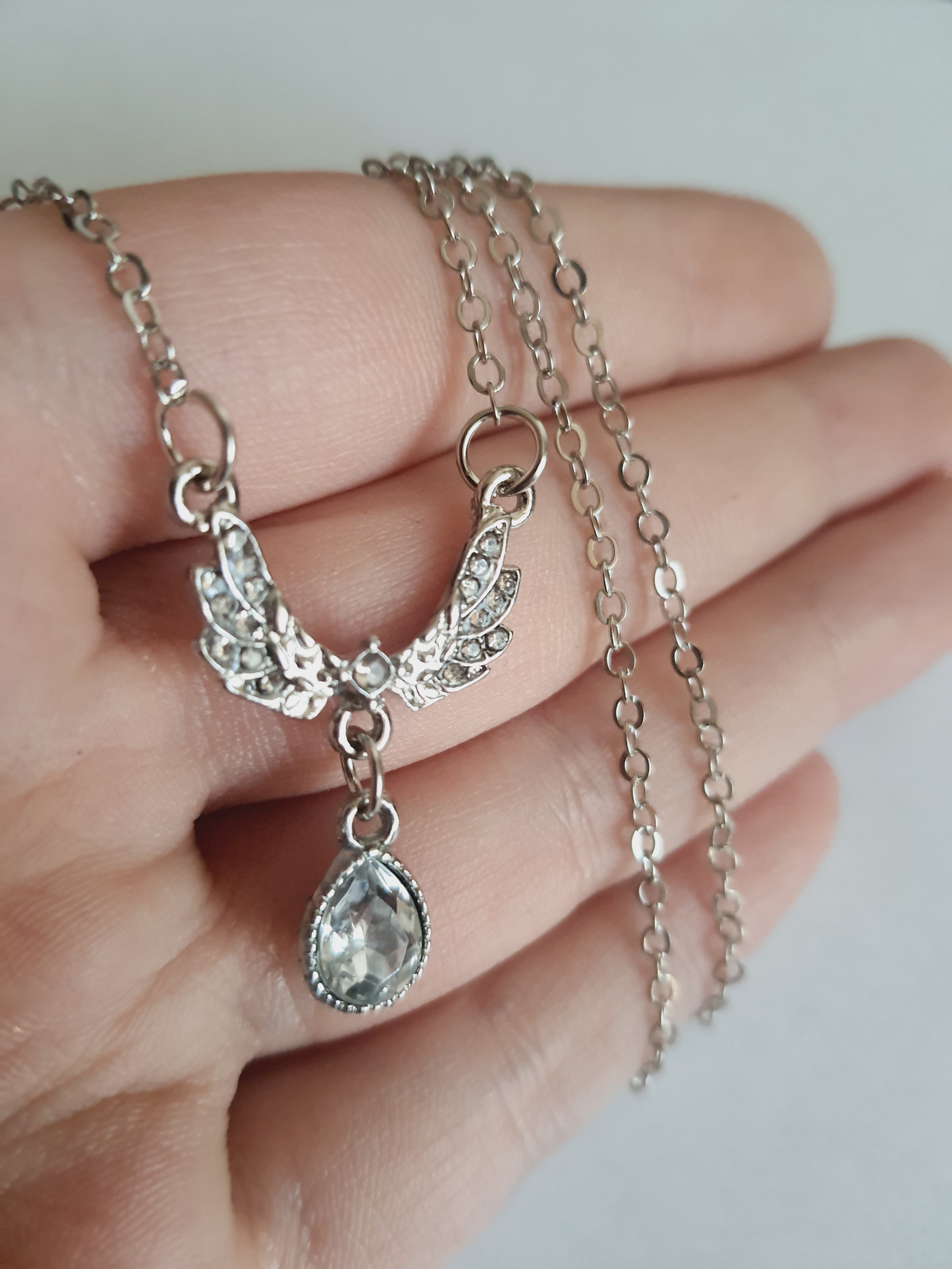 Srebrny naszyjnik ze stali nierdzewnej – stal chirurgiczna, wodoodporny, hipoalergiczny, jakość premium. Zawieszka w kształcie gołębia wysadzanego cyrkoniami z kryształową łzą. Długość łańcuszka 42–49 cm. RougeBizu.