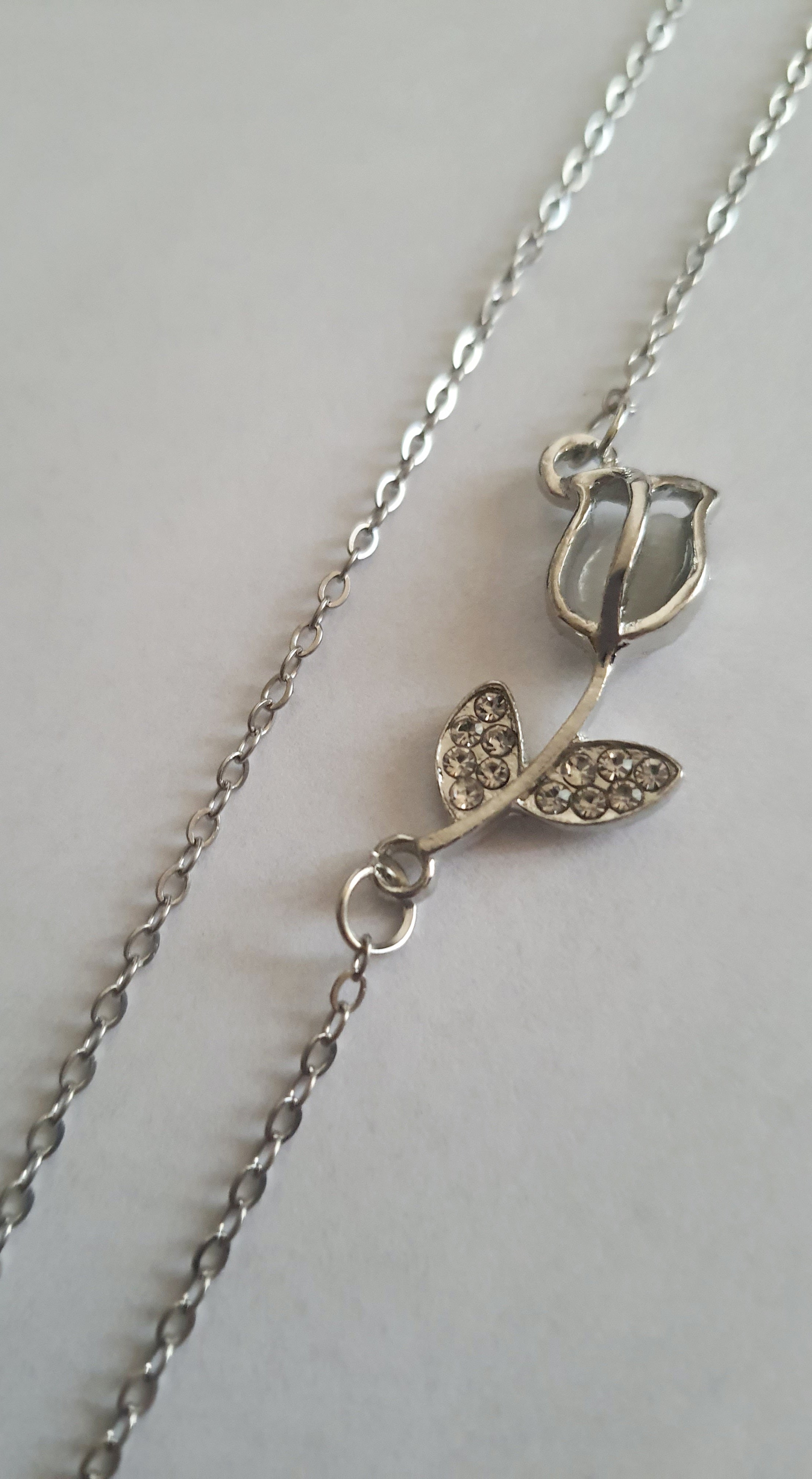 Srebrny naszyjnik ze stali nierdzewnej – stal chirurgiczna, wodoodporny, hipoalergiczny, jakość premium. Zawieszka w kształcie róży z listkami ozdobionymi cyrkoniami. Długość łańcuszka 42–49 cm. RougeBizu.