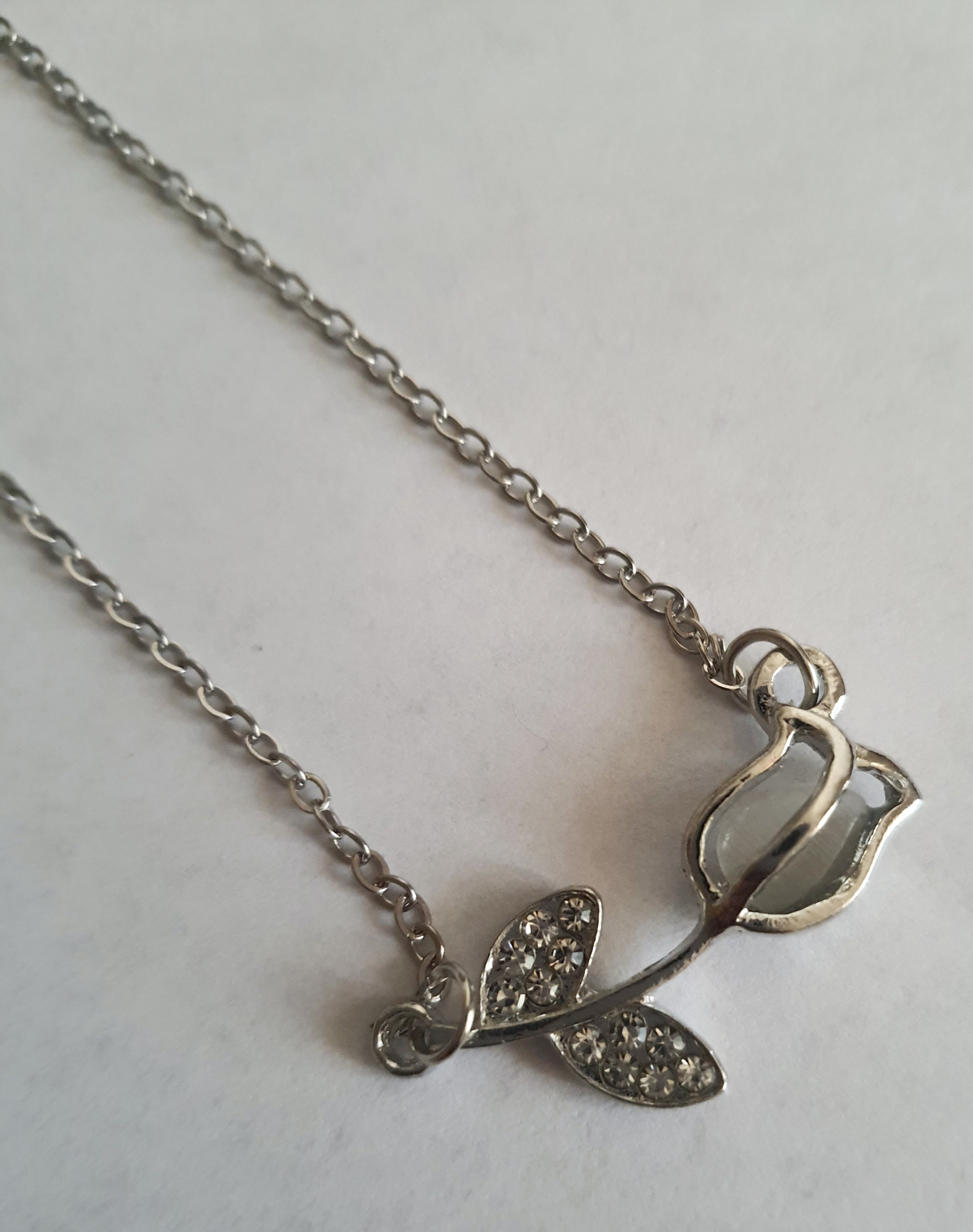 Srebrny naszyjnik ze stali nierdzewnej – stal chirurgiczna, wodoodporny, hipoalergiczny, jakość premium. Zawieszka w kształcie róży z listkami ozdobionymi cyrkoniami. Długość łańcuszka 42–49 cm. RougeBizu.