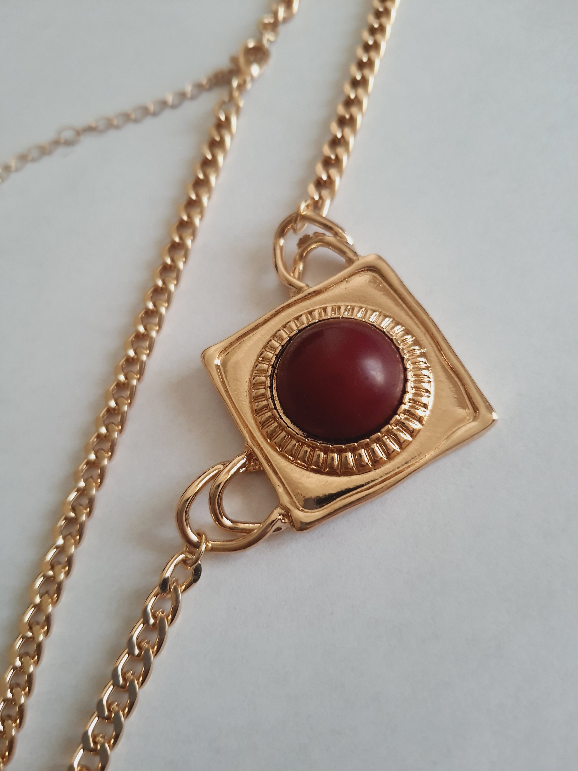 Złoty naszyjnik retro vintage ze stali nierdzewnej – stal chirurgiczna, wodoodporny, hipoalergiczny, jakość premium. Kwadratowa zawieszka z czerwonym kamieniem. Długość łańcuszka 45–53 cm. RougeBizu.