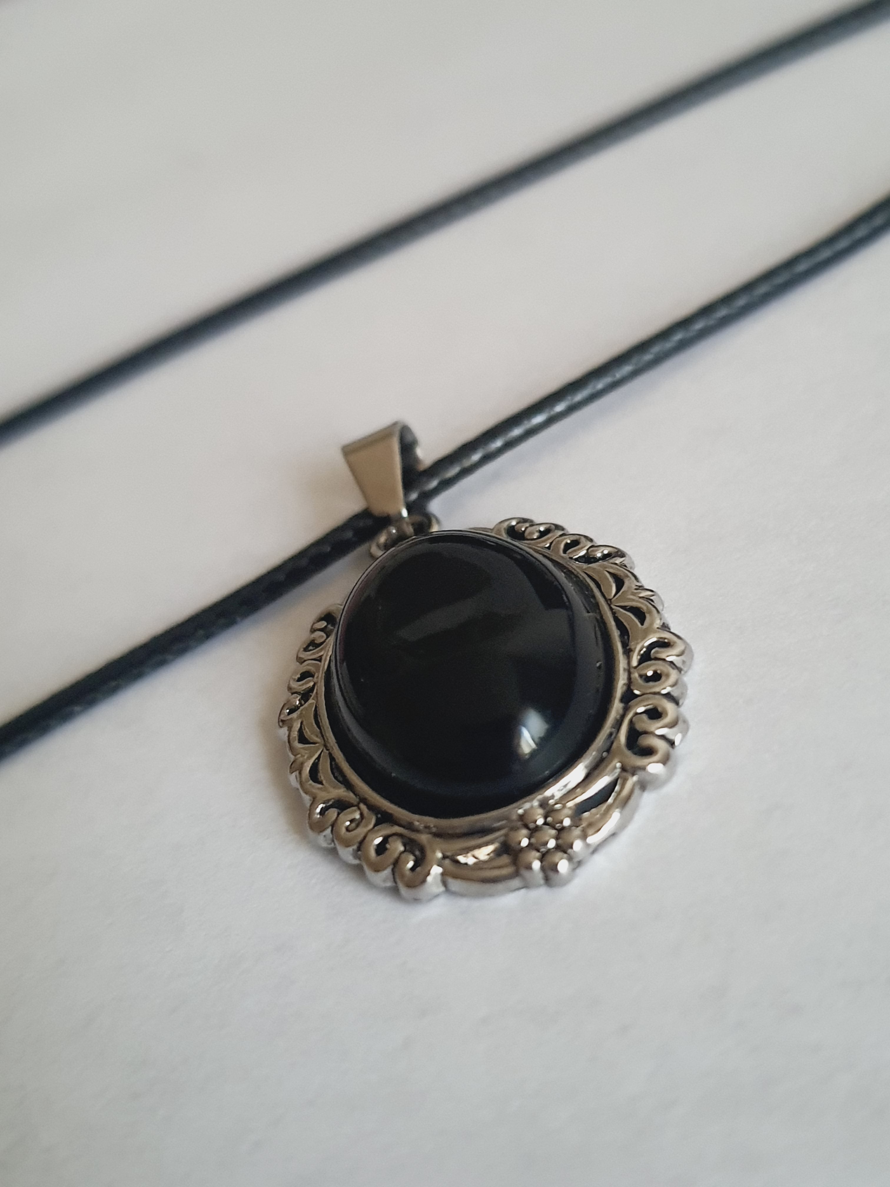 Naszyjnik vintage na rzemyku z syntetycznym obsydianem w srebrnej, zdobionej ramie, owalny czarny kamień, styl retro glamour, stal nierdzewna, stal chirurgiczna, wodoodporne, hipoalergiczne, jakość premium, Rouge Bizu.