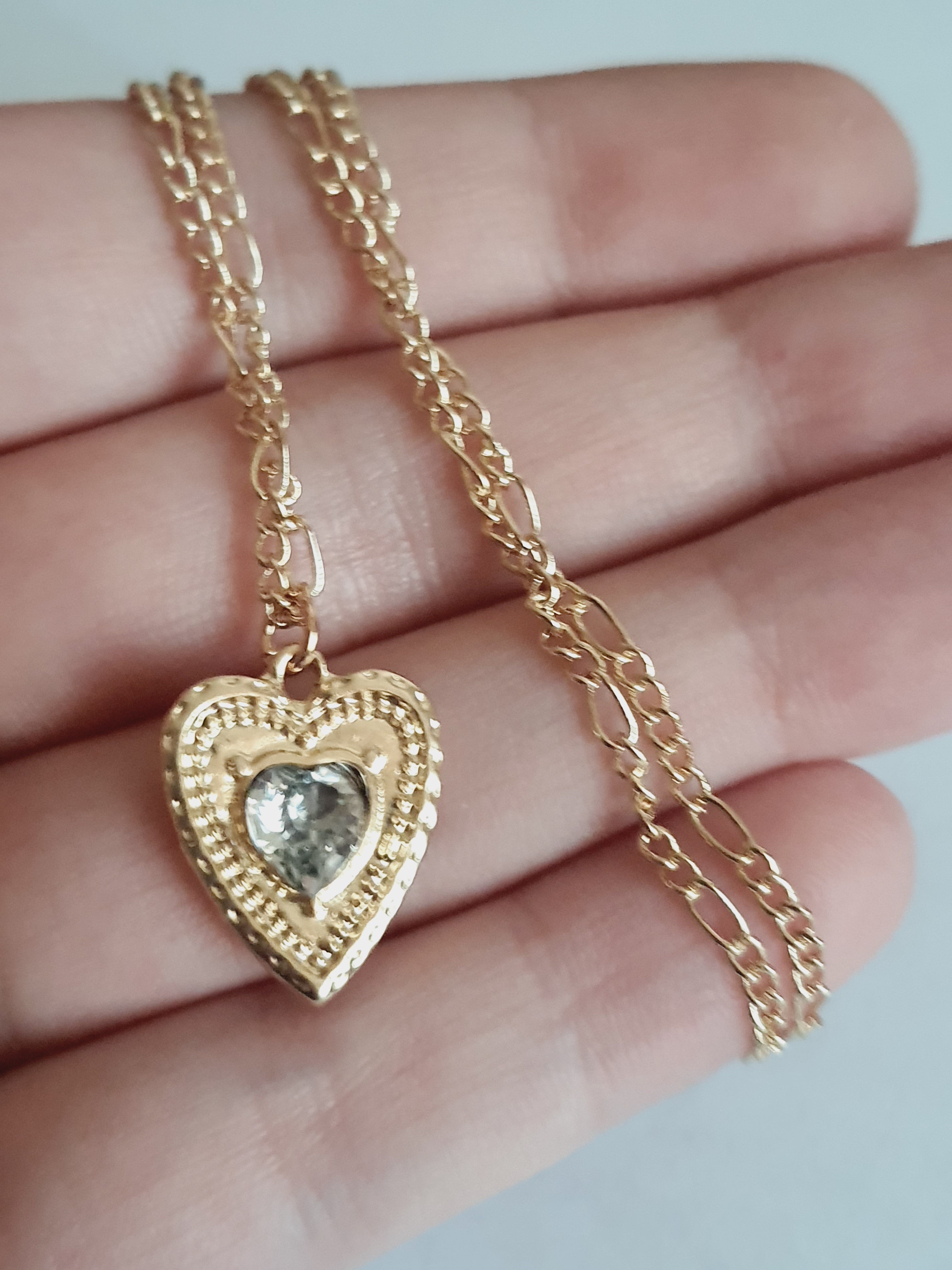 Złoty naszyjnik ze stali chirurgicznej, łańcuszek 43–50 cm, zawieszka w kształcie serca z centralnym kryształem, elegancja i romantyczny styl. Stal nierdzewna, wodoodporne, hipoalergiczne, jakość premium. Rouge Bizu.