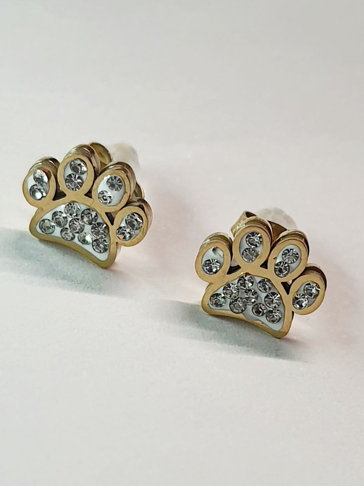 Złote kolczyki w kształcie psich łapek z przezroczystymi cyrkoniami, średnica 1 cm, stal chirurgiczna, stal nierdzewna, wodoodporne, hipoalergiczne, jakość premium, elegancki styl, Rouge Bizu.