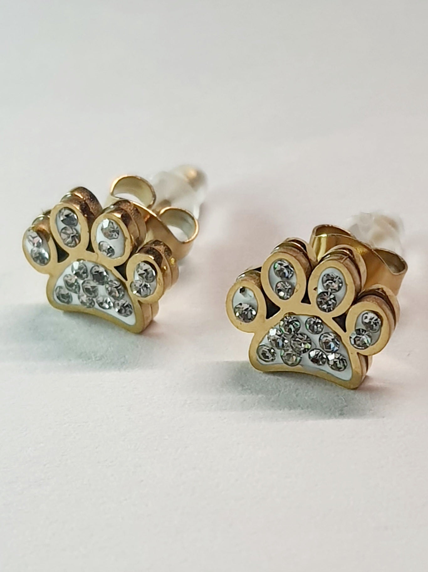 Złote kolczyki w kształcie psich łapek z przezroczystymi cyrkoniami, średnica 1 cm, stal chirurgiczna, stal nierdzewna, wodoodporne, hipoalergiczne, jakość premium, elegancki styl, Rouge Bizu.