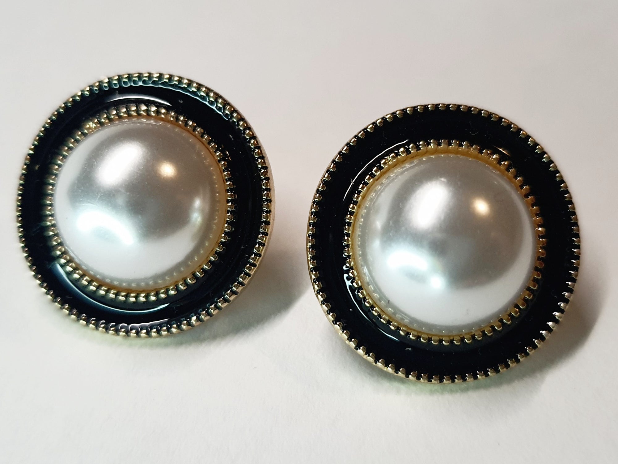 Okrągłe kolczyki w złotej oprawie z czarnym akcentem i dużą perłą pośrodku, styl retro glamour, średnica 2,2 cm. Stal nierdzewna, stal chirurgiczna, wodoodporne, hipoalergiczne, jakość premium, RougeBizu.