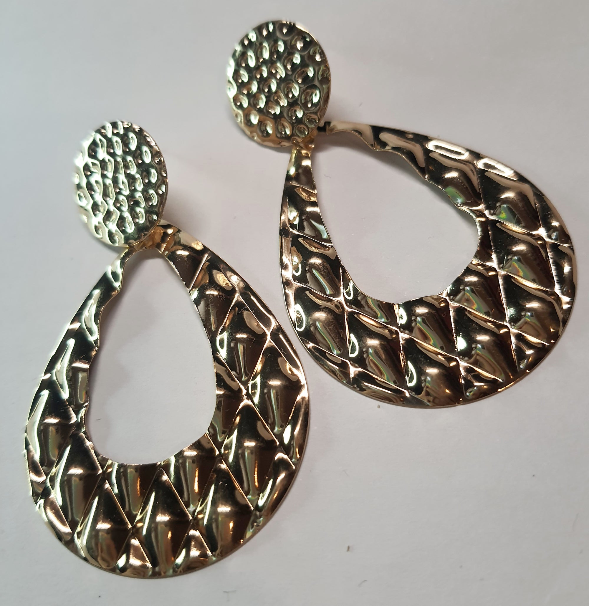 Długie złote kolczyki o młotkowanej fakturze, w kształcie łezki, długość 7,5 cm. Styl statement glamour. Stal nierdzewna, stal chirurgiczna, wodoodporne, hipoalergiczne, jakość premium, RougeBizu.