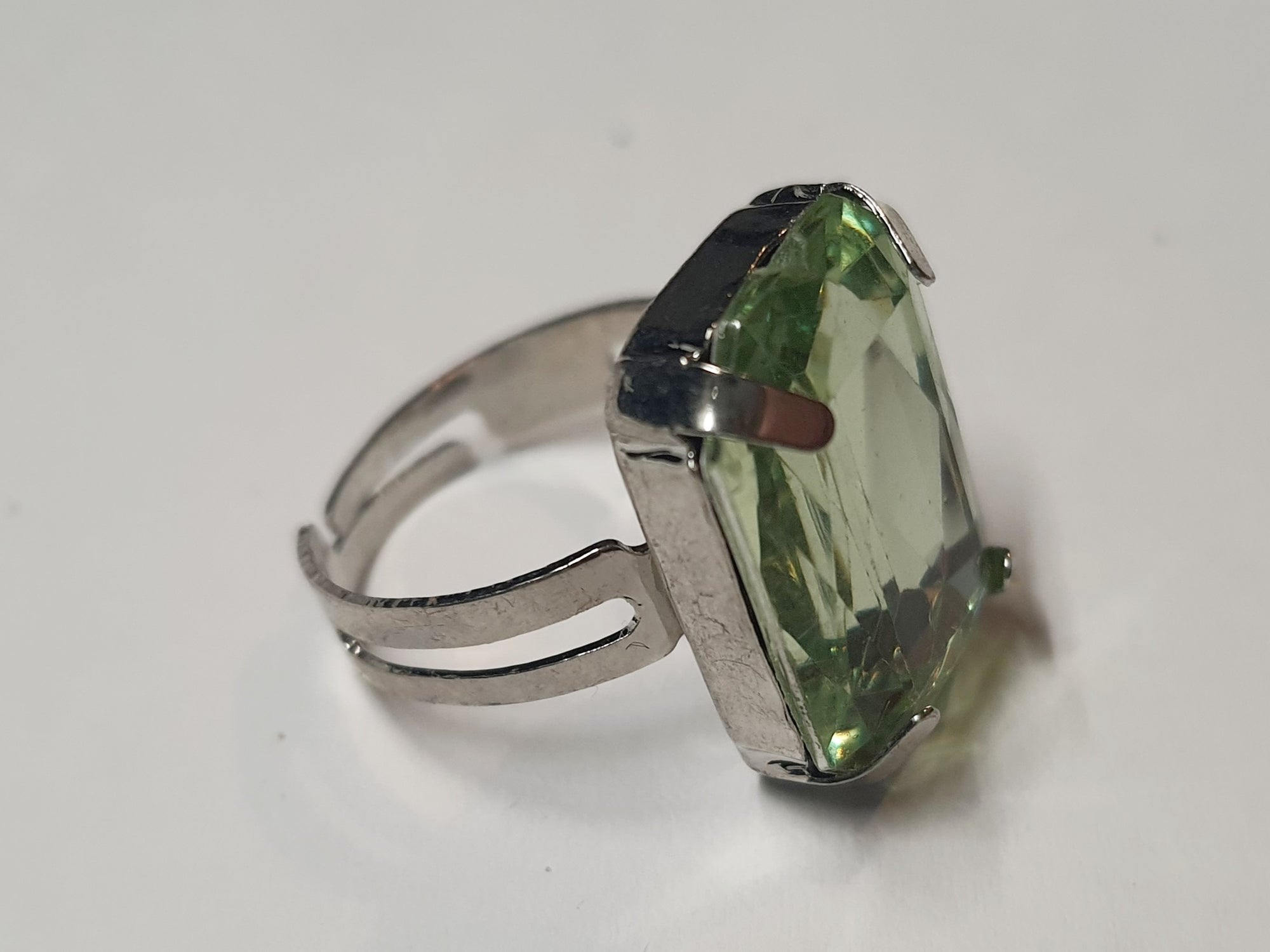 Srebrny pierścionek z dużym zielonym prostokątnym kamieniem, metal, szlifowany kamień o eleganckim połysku, rozmiar 17 mm z regulacją, styl klasyczny, Rouge Bizu.