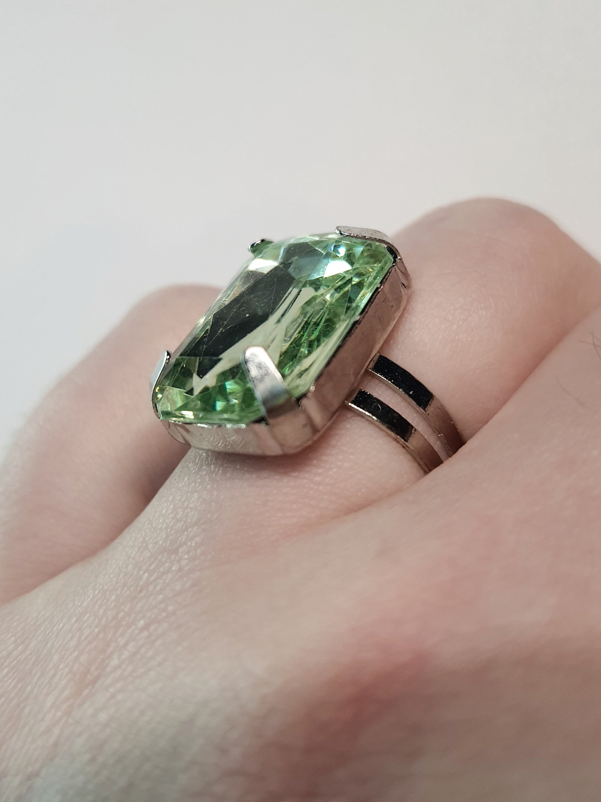 Srebrny pierścionek z dużym zielonym prostokątnym kamieniem, metal, szlifowany kamień o eleganckim połysku, rozmiar 17 mm z regulacją, styl klasyczny, Rouge Bizu.