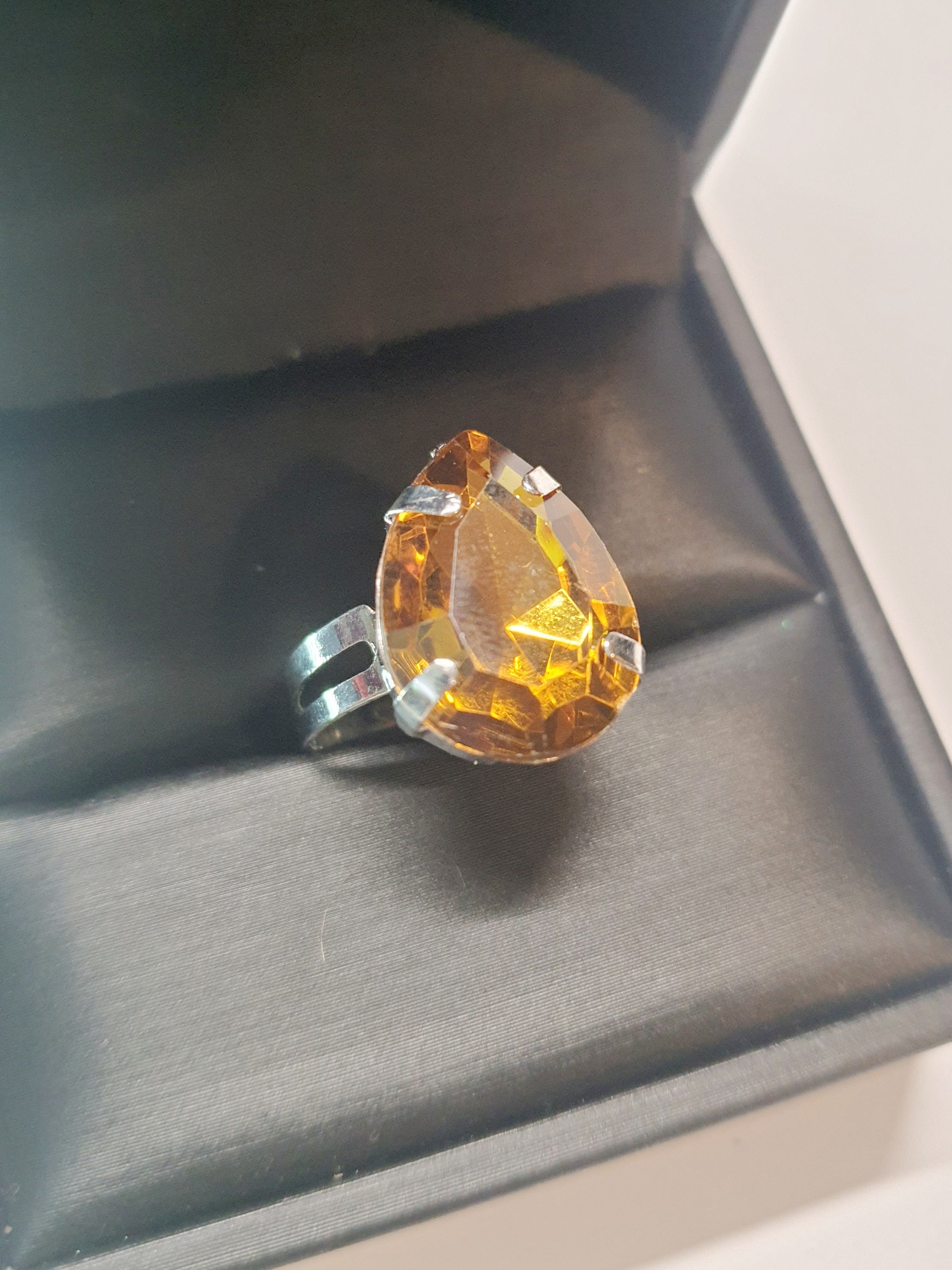 Srebrny pierścionek z dużym miodowym kamieniem w kształcie łzy, metal, elegancki styl glamour, szlifowany kamień o bursztynowym odcieniu, regulowany, Rouge Bizu.