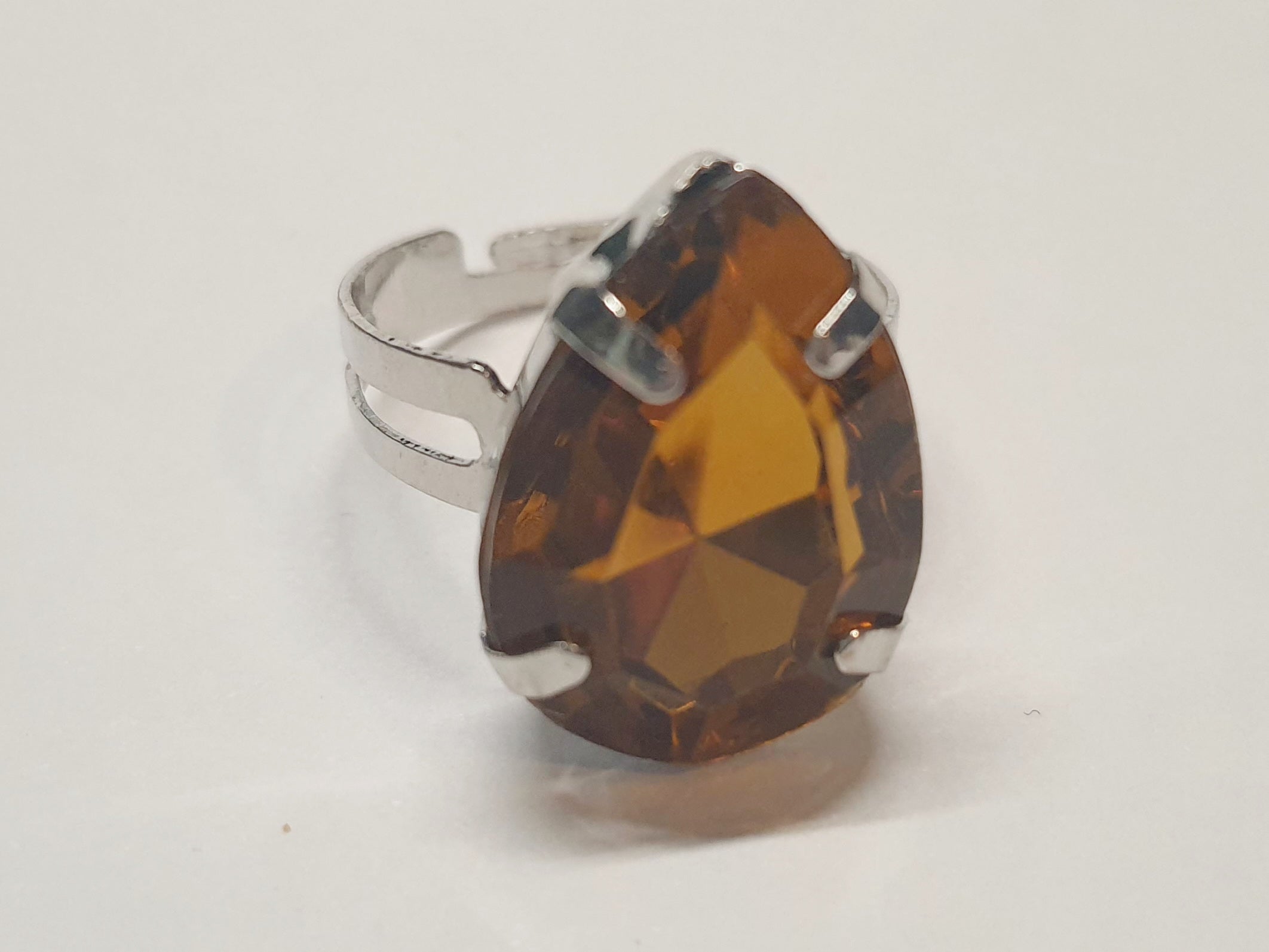 Srebrny pierścionek z dużym miodowym kamieniem w kształcie łzy, metal, elegancki styl glamour, szlifowany kamień o bursztynowym odcieniu, regulowany, Rouge Bizu.