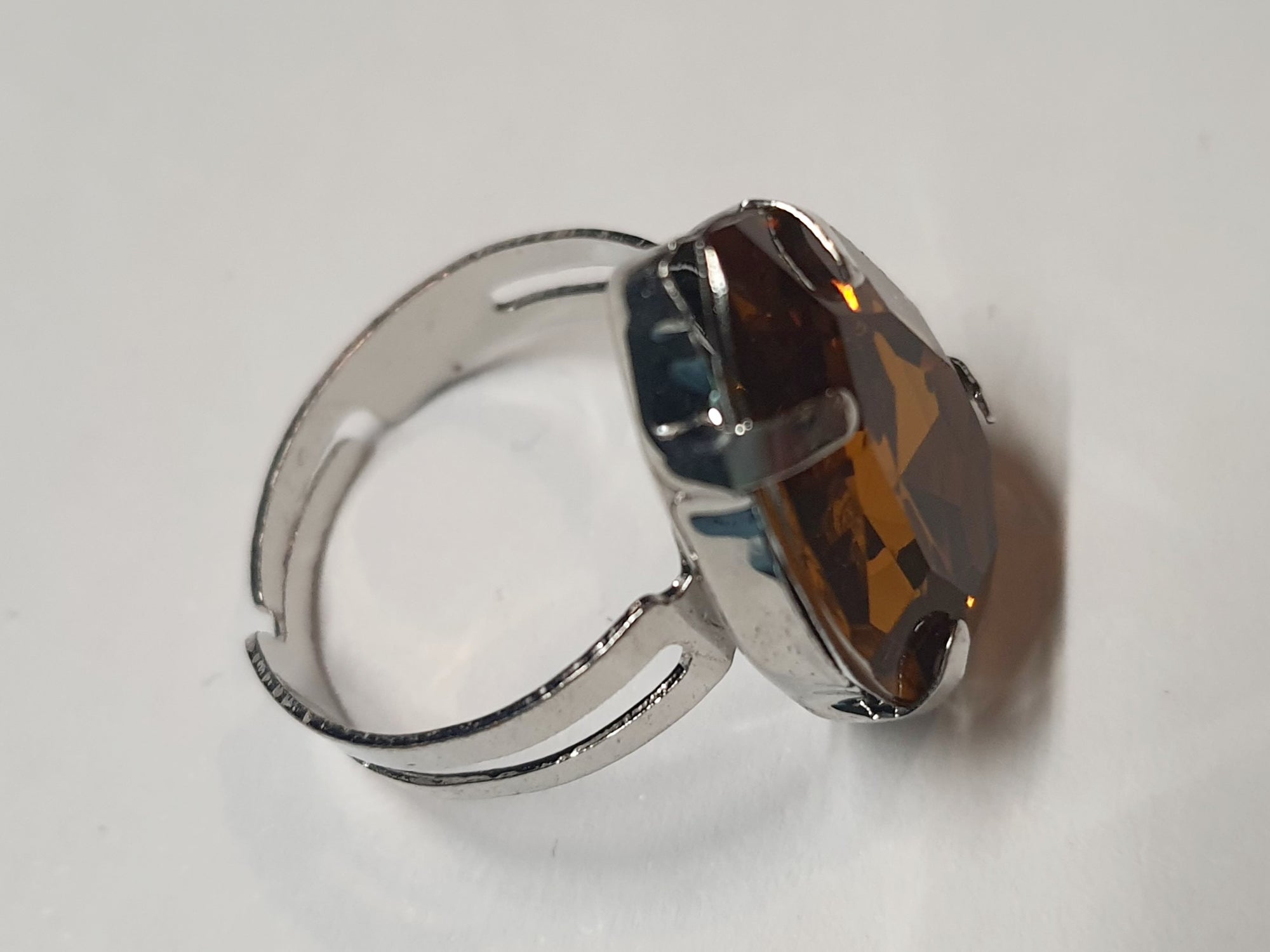 Srebrny pierścionek z dużym miodowym kamieniem w kształcie łzy, metal, elegancki styl glamour, szlifowany kamień o bursztynowym odcieniu, regulowany, Rouge Bizu.
