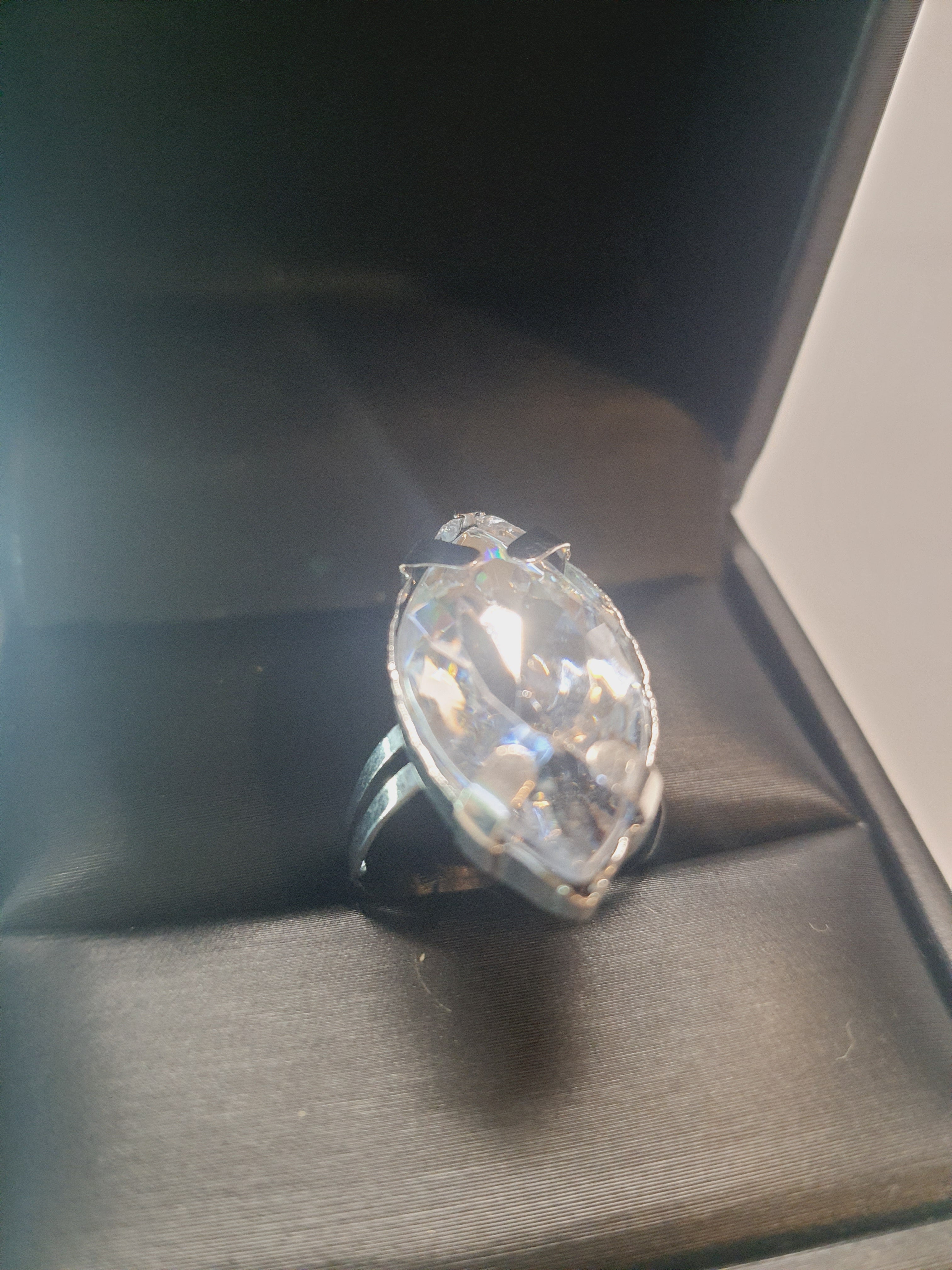 Srebrny pierścionek z dużym transparentnym kamieniem w kształcie łezki, metal, szlifowany kamień o lśniącym połysku, styl glamour, regulowany rozmiar, Rouge Bizu.