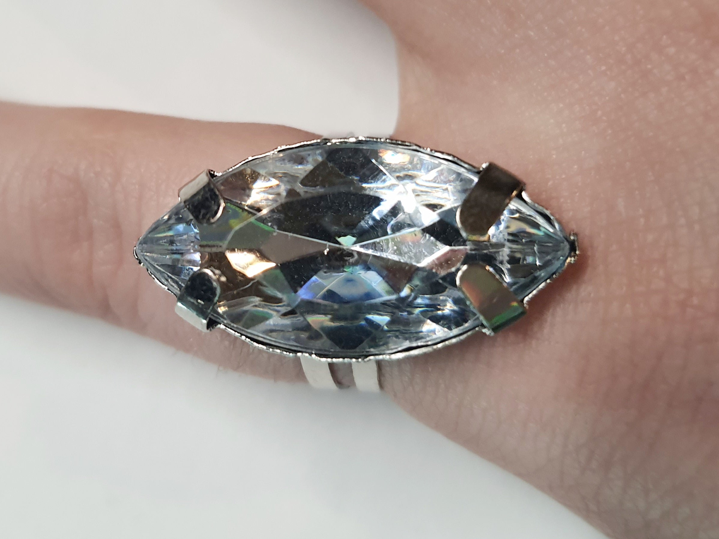 Srebrny pierścionek z dużym transparentnym kamieniem w kształcie łezki, metal, szlifowany kamień o lśniącym połysku, styl glamour, regulowany rozmiar, Rouge Bizu.