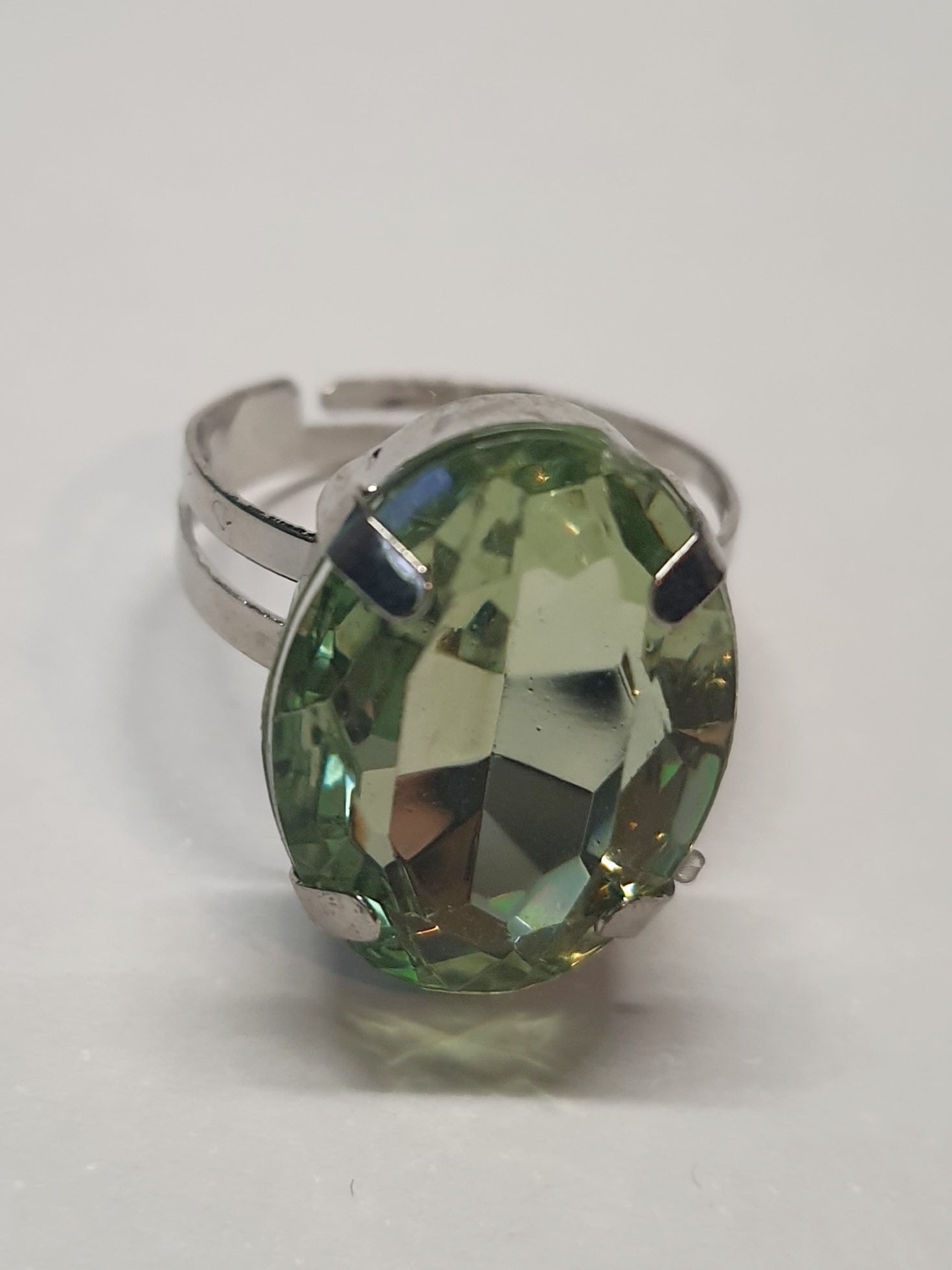 Srebrny pierścionek z dużym oliwkowo-zielonym owalnym kamieniem, metal, elegancki styl, szlifowany kamień o subtelnym połysku, regulowany rozmiar, Rouge Bizu.