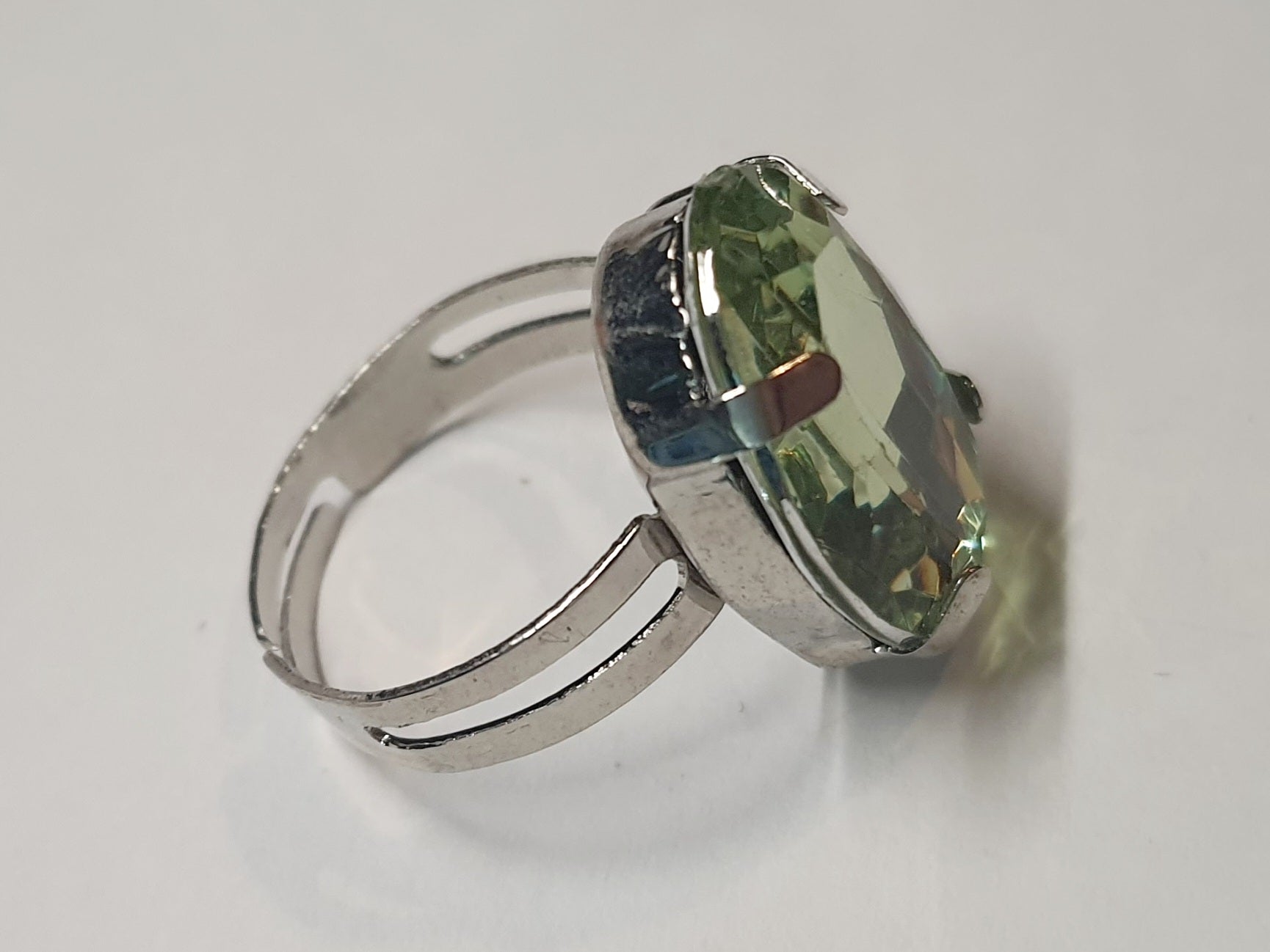 Srebrny pierścionek z dużym oliwkowo-zielonym owalnym kamieniem, metal, elegancki styl, szlifowany kamień o subtelnym połysku, regulowany rozmiar, Rouge Bizu.