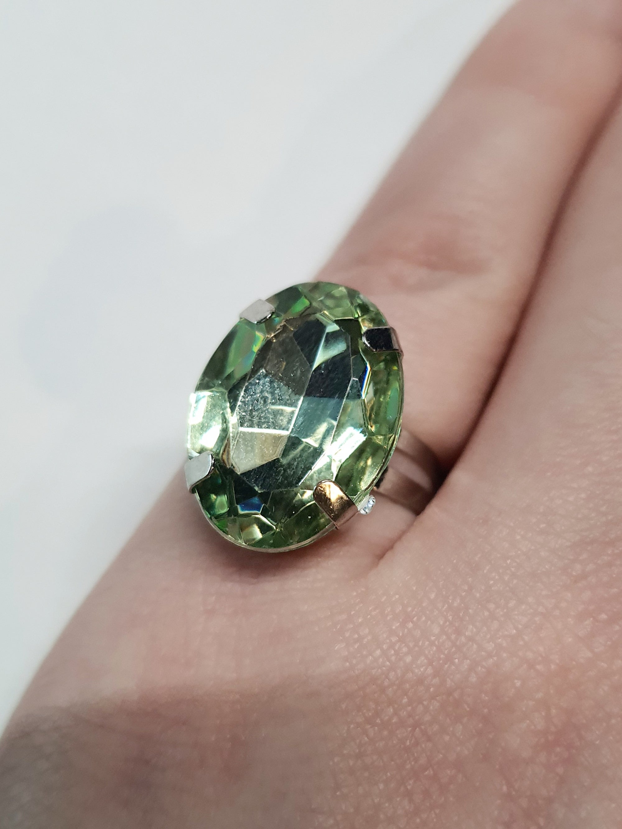 Srebrny pierścionek z dużym oliwkowo-zielonym owalnym kamieniem, metal, elegancki styl, szlifowany kamień o subtelnym połysku, regulowany rozmiar, Rouge Bizu.