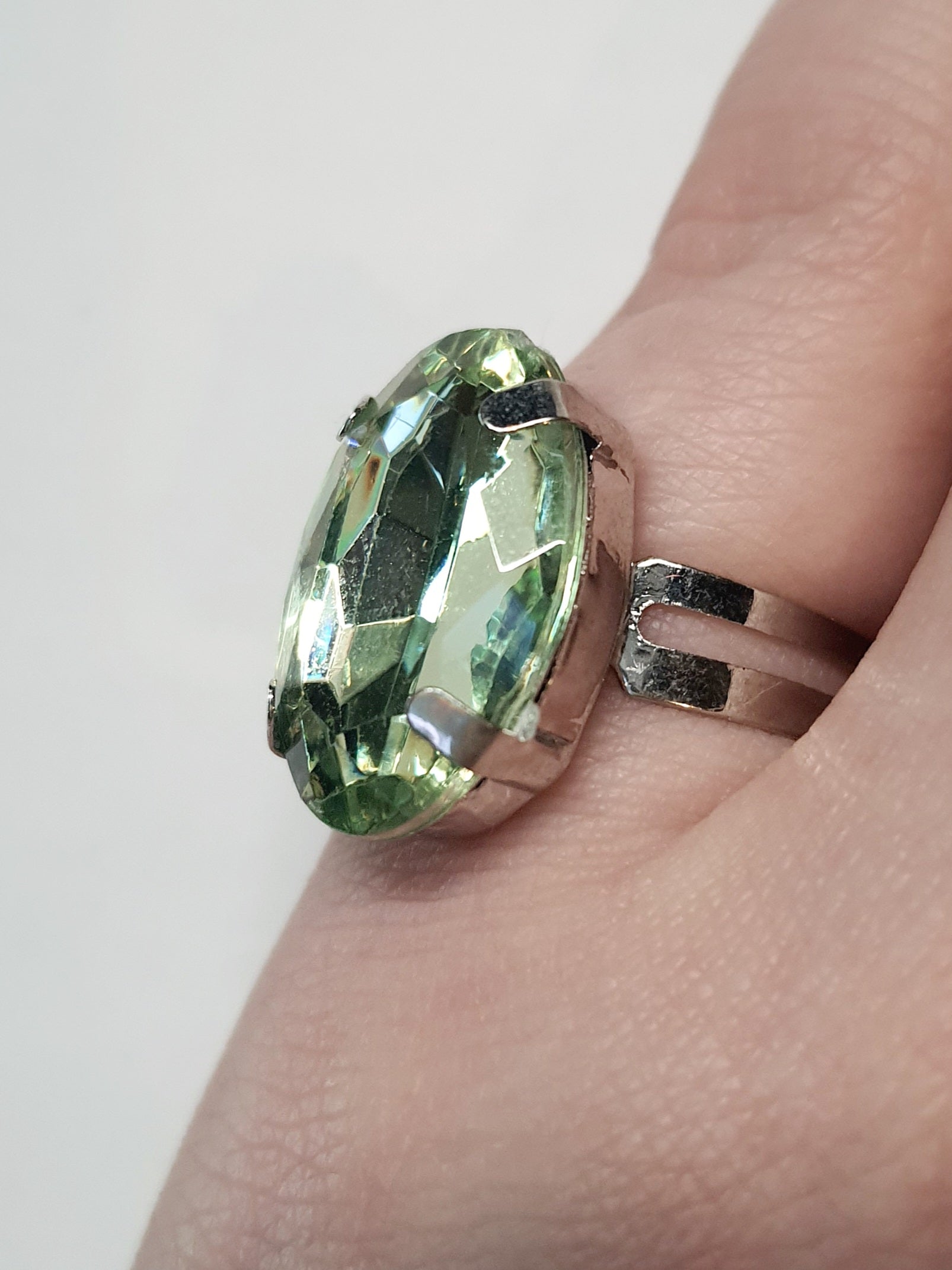 Srebrny pierścionek z dużym oliwkowo-zielonym owalnym kamieniem, metal, elegancki styl, szlifowany kamień o subtelnym połysku, regulowany rozmiar, Rouge Bizu.