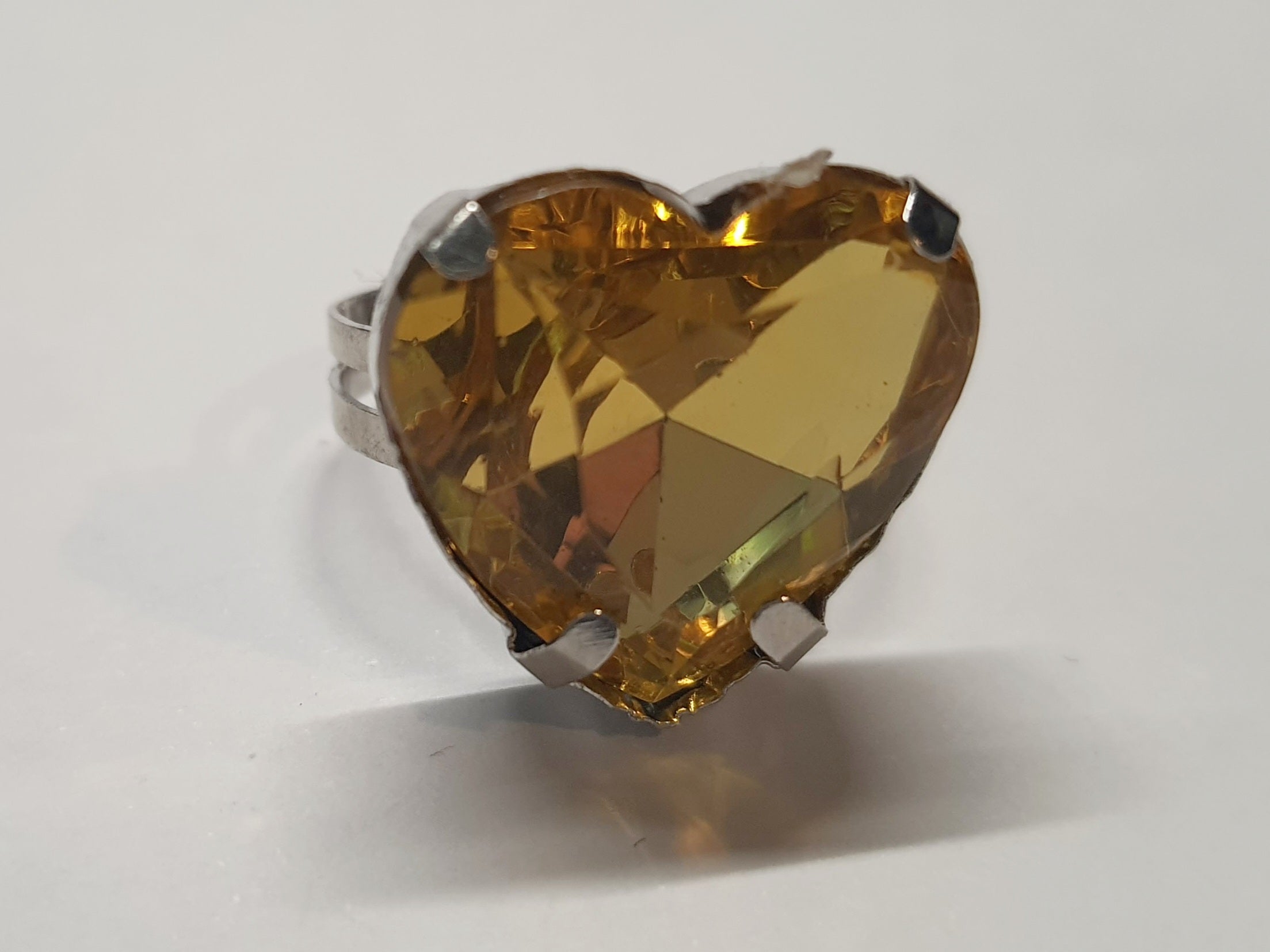 Srebrny pierścionek z dużym miodowo-złotym kamieniem w kształcie serca, metal, szlifowany kamień o ciepłym blasku, styl romantyczny glamour, regulowany rozmiar, Rouge Bizu.